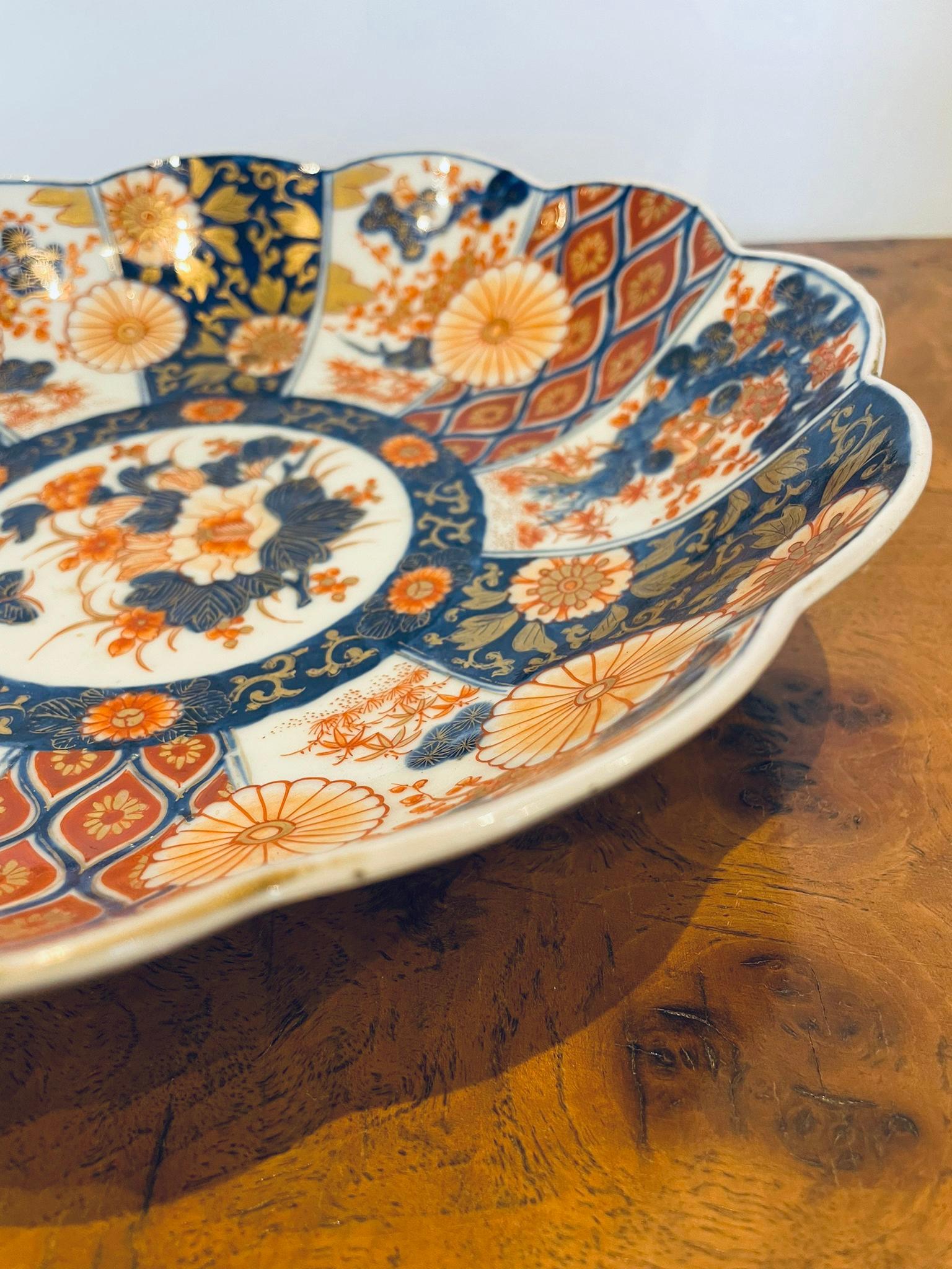 Fine quality antique Japanese Imari bowl having a scalloped shaped edge and fine quality hand painted panels with flowers, leaves, trees and butterflies in wonderful blue, red, orange and gold colours.

Measures: 5.5 x 25 x 25cm 
Date 1900.


