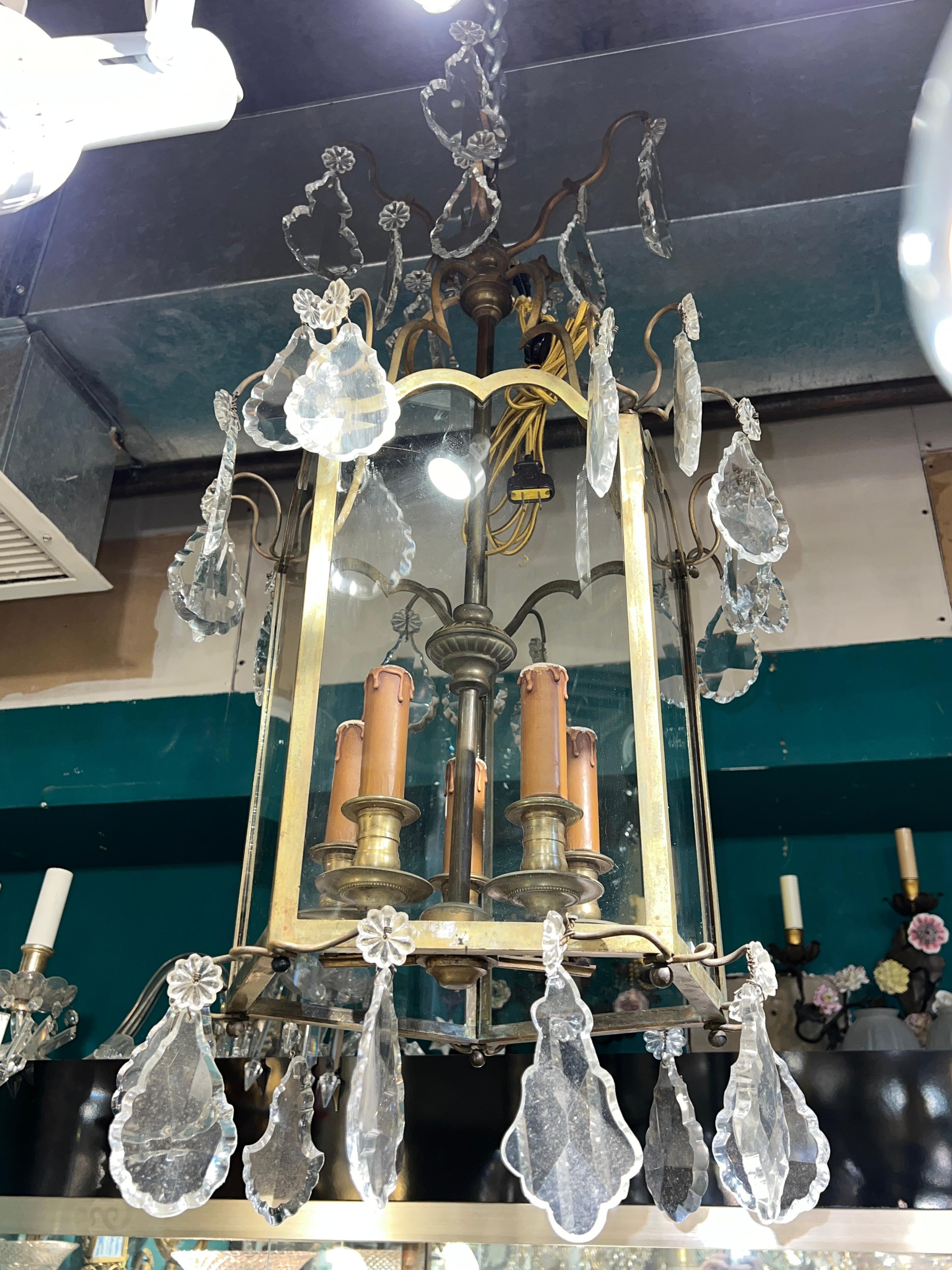 Large, antique lantern with faceted crystal pendants and four electrified candles with faux wax covers dating from the late 19th to early 20th century, with modern wiring and plug, ready for use.