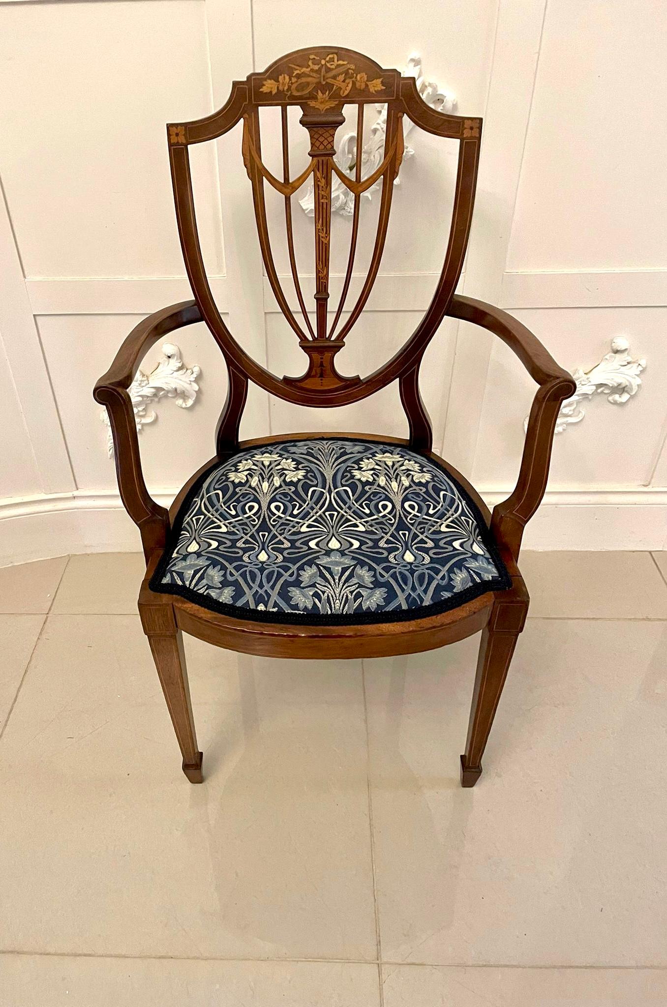 Fine quality antique mahogany inlaid desk chair having a fine quality mahogany inlaid shield-shaped back inlaid with musical instruments in satinwood, newly reupholstered serpentine shaped seat in a quality fabric, shaped open arms with satinwood