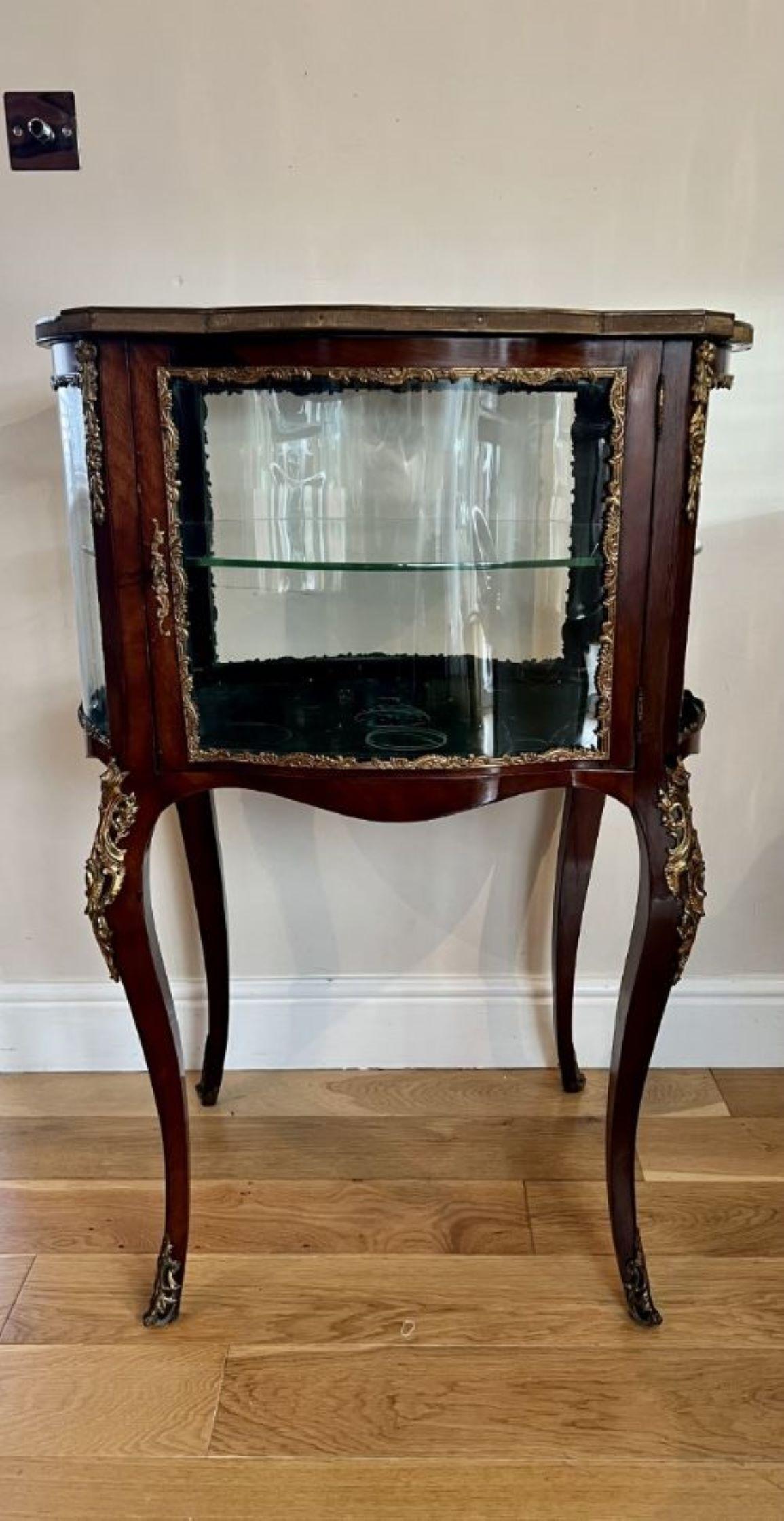 Fine quality antique Victorian French freestanding ormolu mounted display cabinet having a fine quality serpentine shaped mahogany and ormolu mounted freestanding display cabinet with one door opening to reveal a glass display shelf standing on