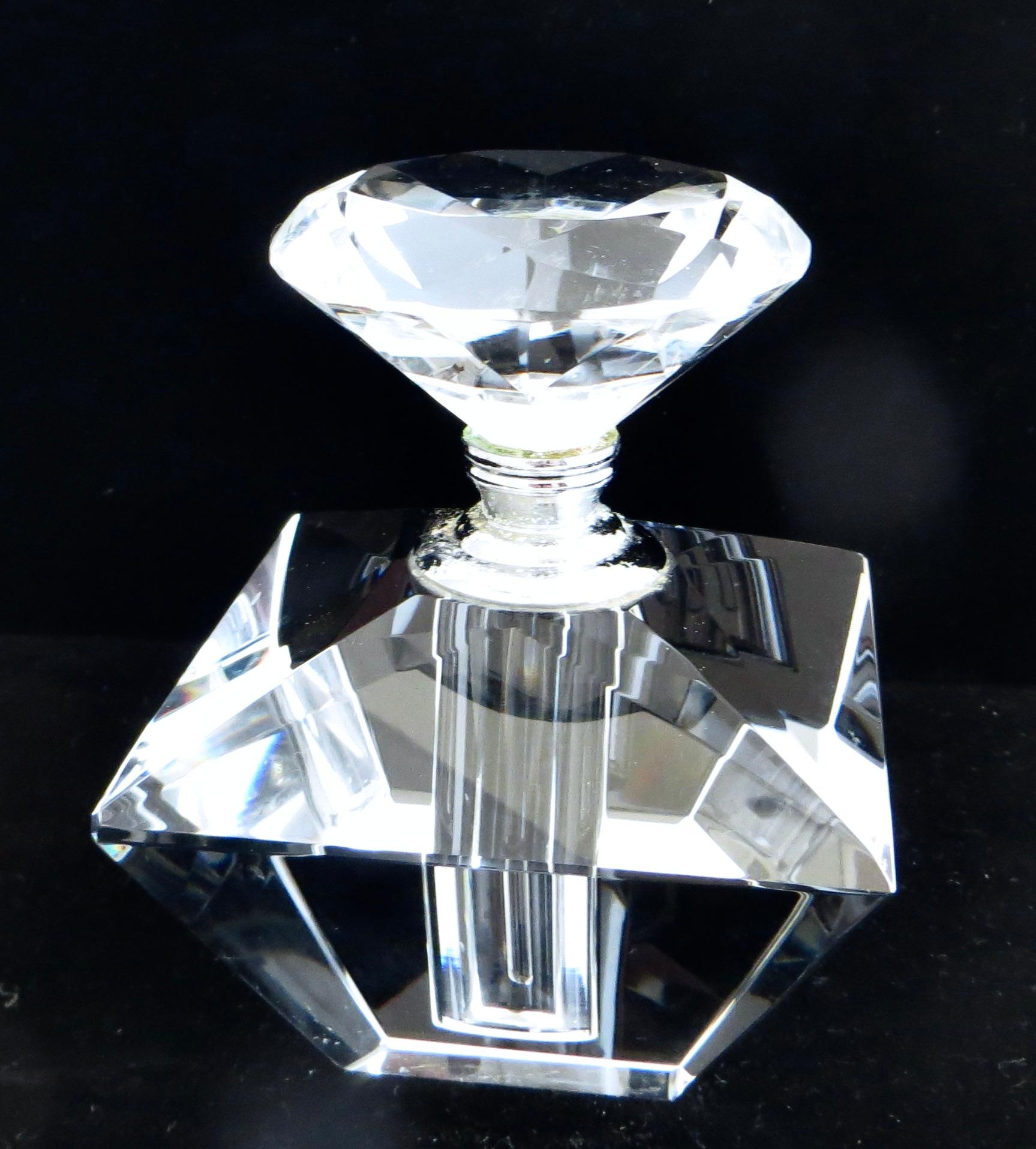 Flacon de parfum Art Déco en verre taillé de forme quadrangulaire à pyramide inversée ; le bouchon à facettes multiples et l'aiguille sont d'origine. Le bouchon et l'aiguille ainsi que le flacon sont en excellent état et entièrement d'origine, sans