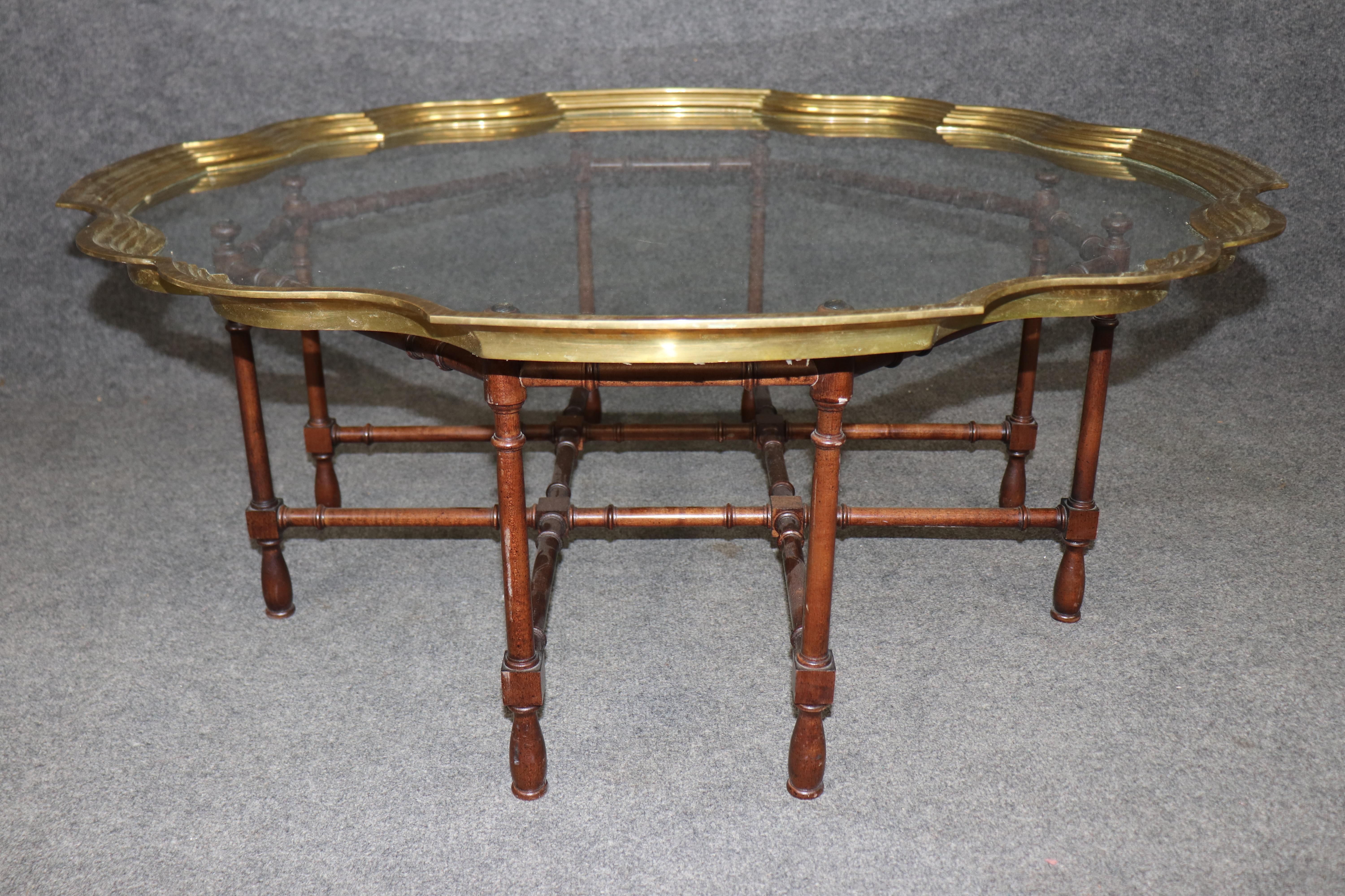 This is a very rare and hard to find Baker Furniture company coffee table in faux bamboo and with a removable glass and brass tray top. The table is practically an iconic design and has become sought after and is therefore hard to find. The table is