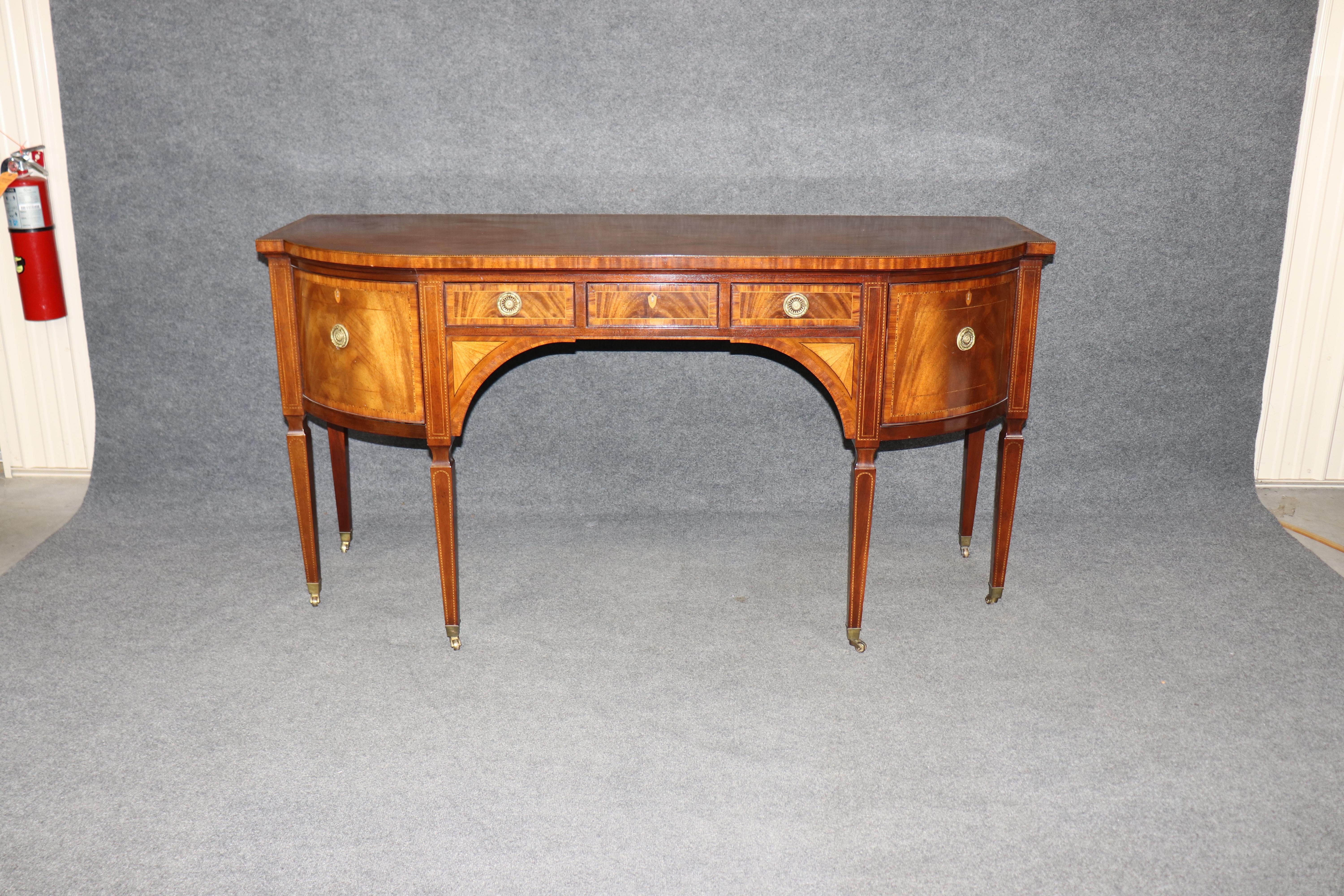 
This is one of Baker's best and last American-made sideboards. They are now made overseas, and the quality will never be as good as older Baker pieces made here. This outstanding Sheraton style sideboard is made with the best mahogany, satinwood