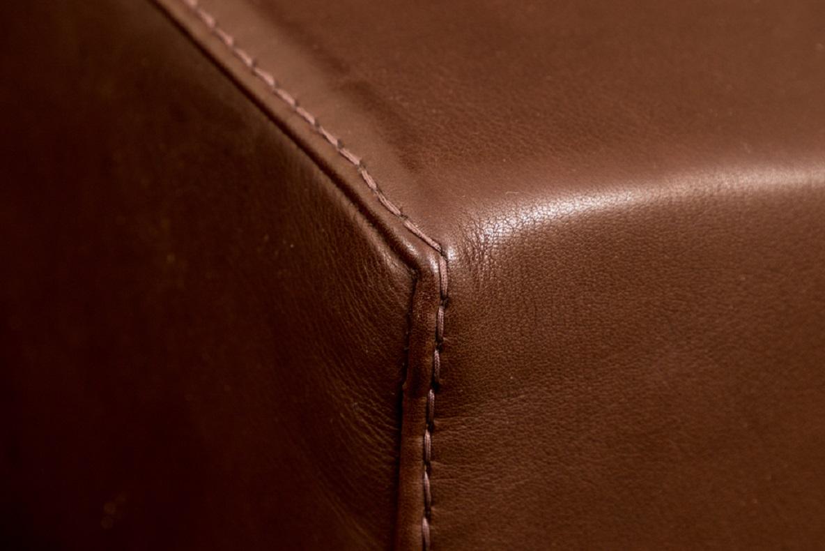 Contemporary brown leather ottoman by Rivolta Italy, square shape in dark brown leather with Fine stitching, mounted on cylindrical metal feet. 

Condition: Gently used condition with light signs of use.