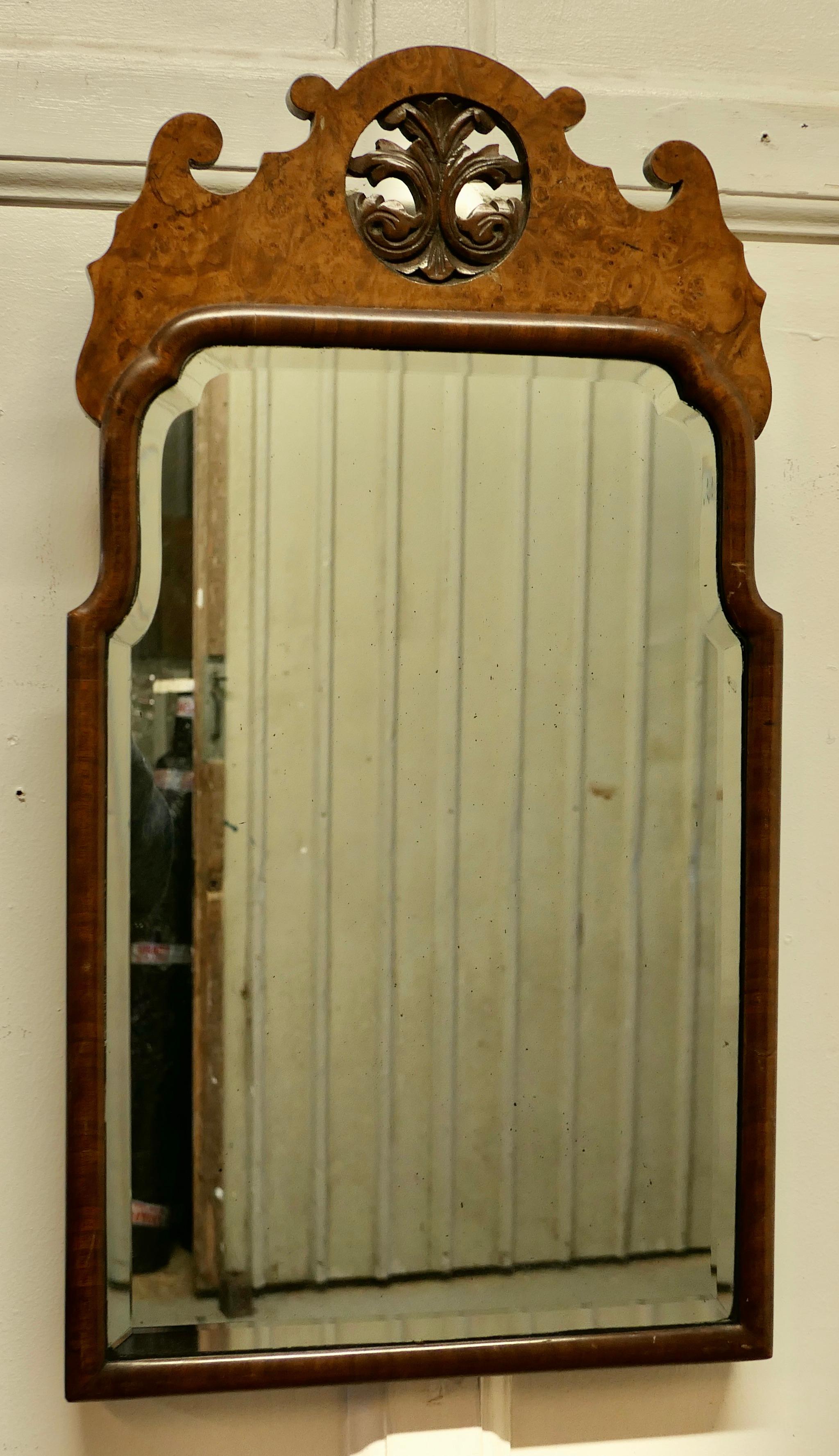Fine quality burr walnut wall hanging mirror.

Here we have a superb wall mirror with a wonderful figured walnut pelmet inset with carved acanthus leaves in the centre.
This is a charming Period piece, unusually shaped as is the bevelled