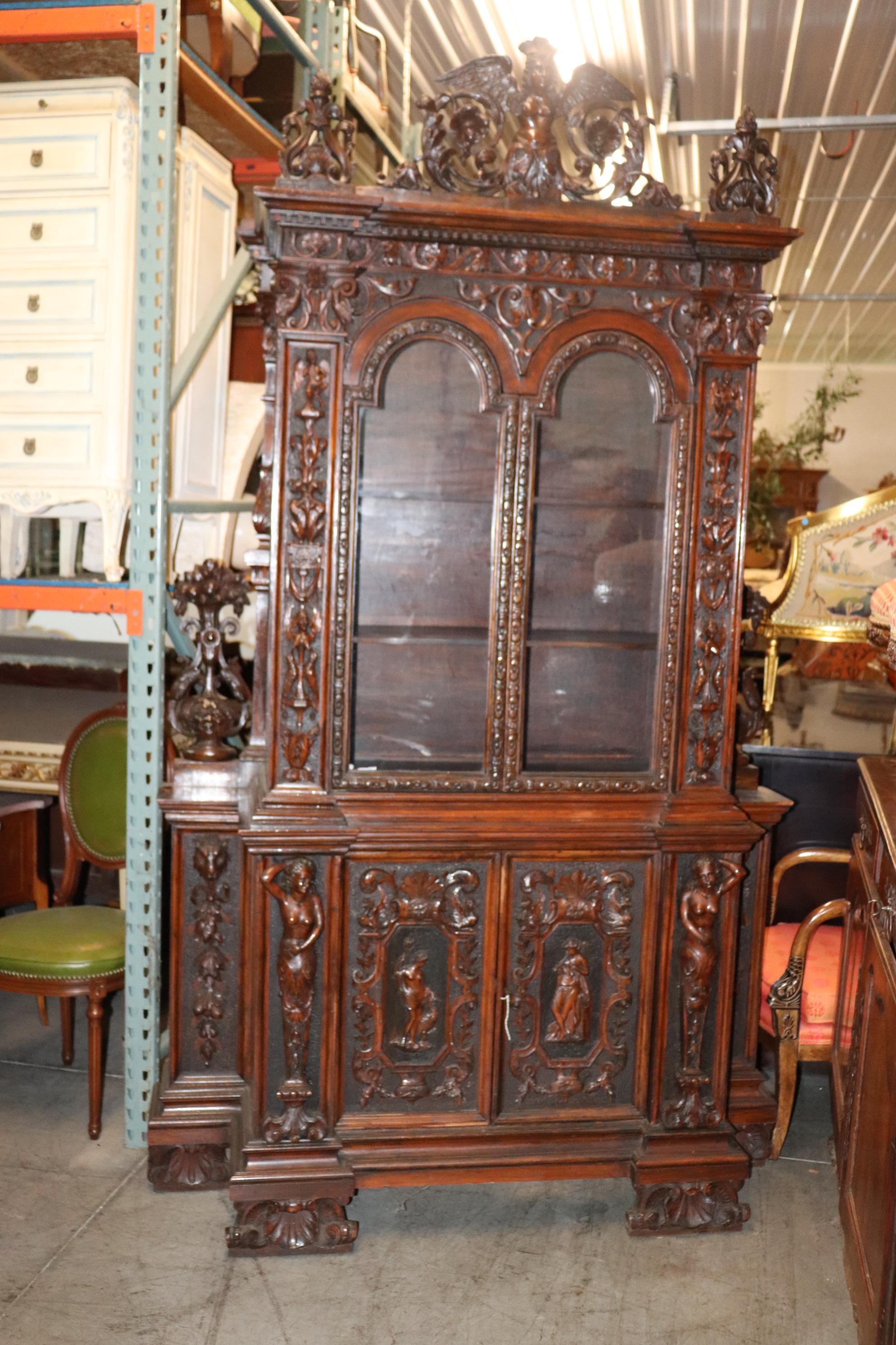 This incredible carved cabinet is an absolute masterpiece of carving and figural design. Look at the incredible quality of the carved details and the stippled areas in the background. The cabinet has hand-blown glass and has some signs of age and