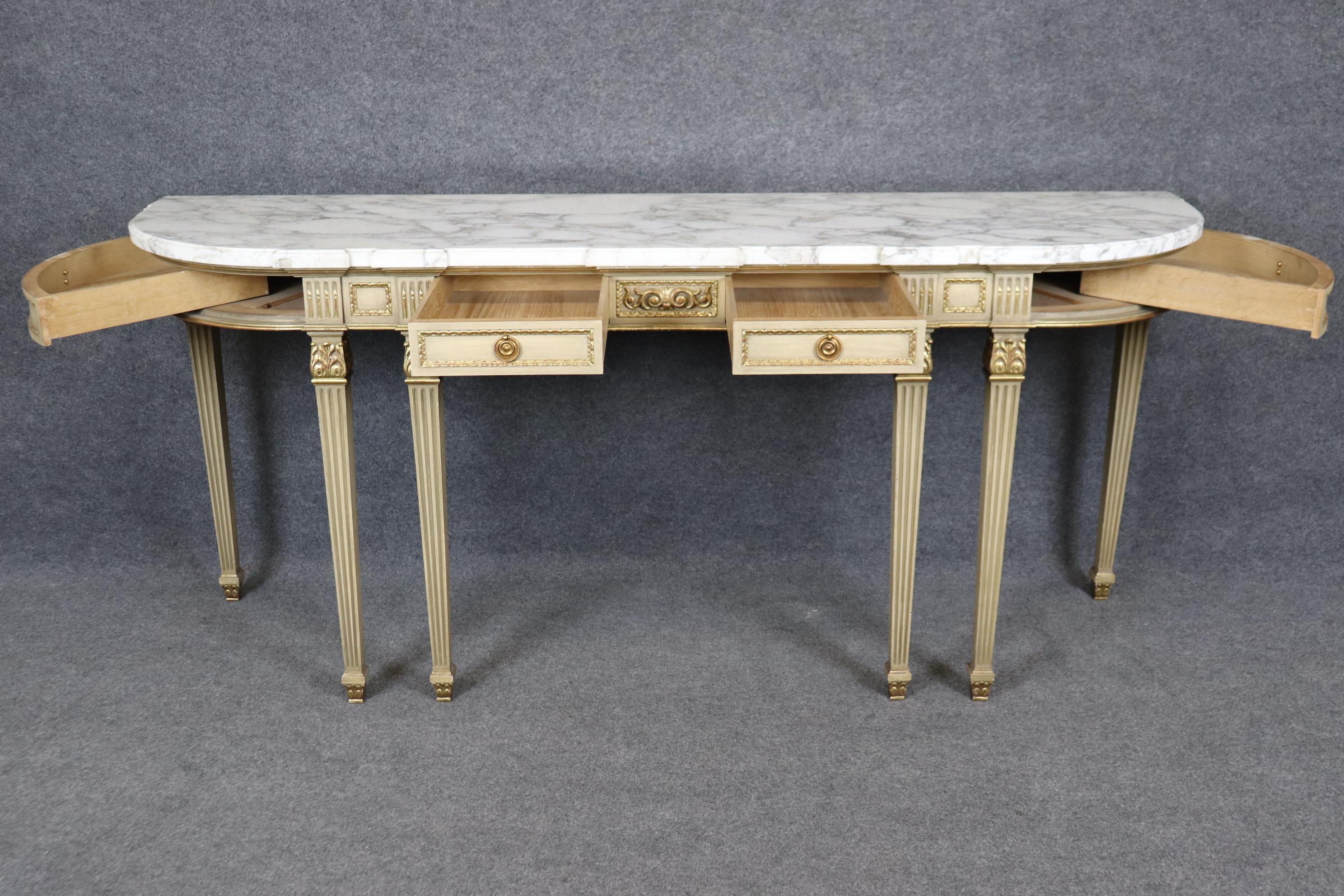 This is an extraordinary marble top console or serving table attributed to Maison Jansen of Paris. The table is in good condition with minimal signs of age and use and has fantastic swing out drawers and plenty of storage for silverware or whatever