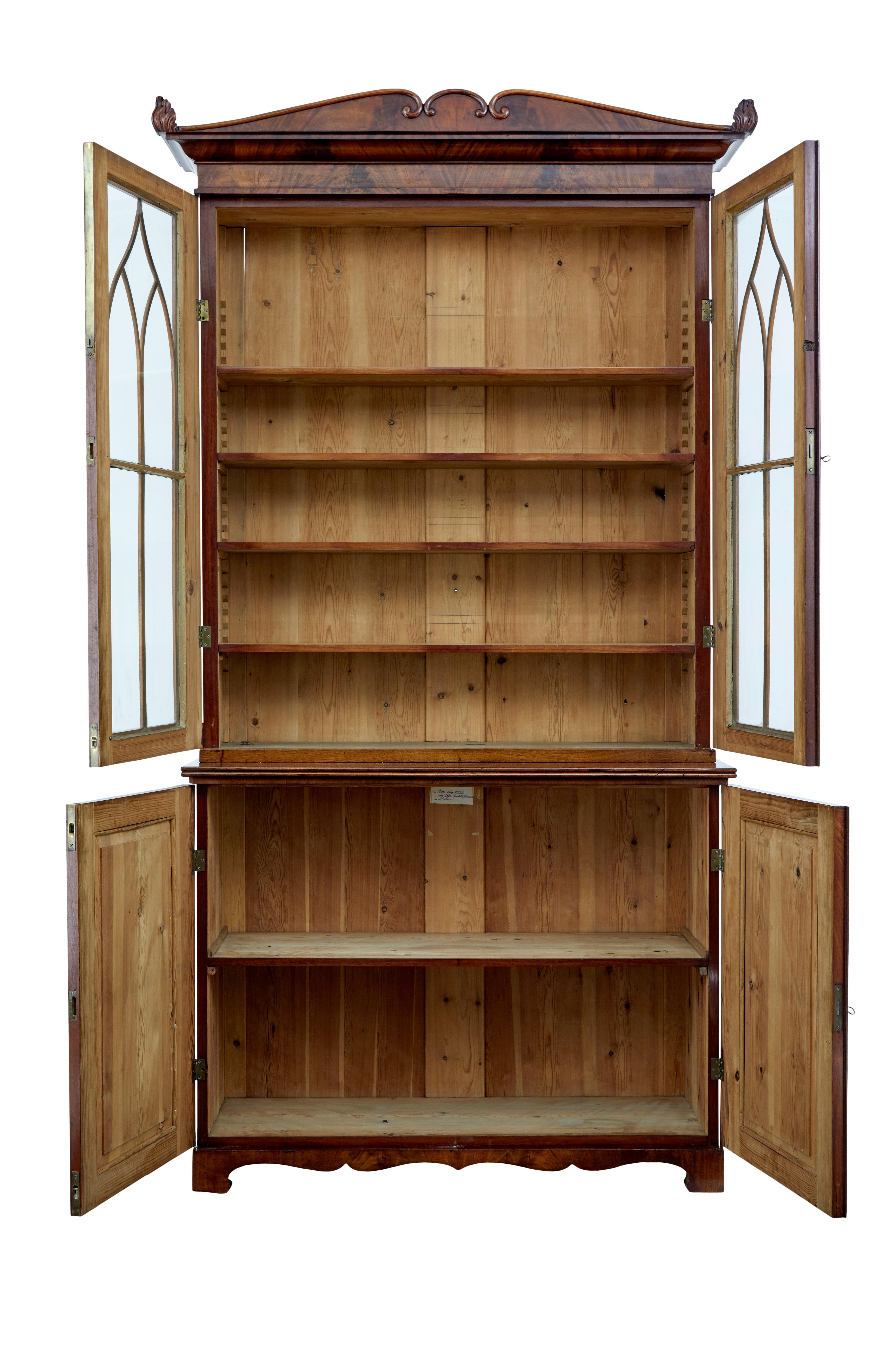 Fine example of a regency period bookcase, circa 1820.

Very much in the manor of Thomas hope. Matching flame mahogany veneers from top to bottom. Comprising of 3 sections, lower cabinet, glazed cabinet and removable cornice.

Shaped cornice