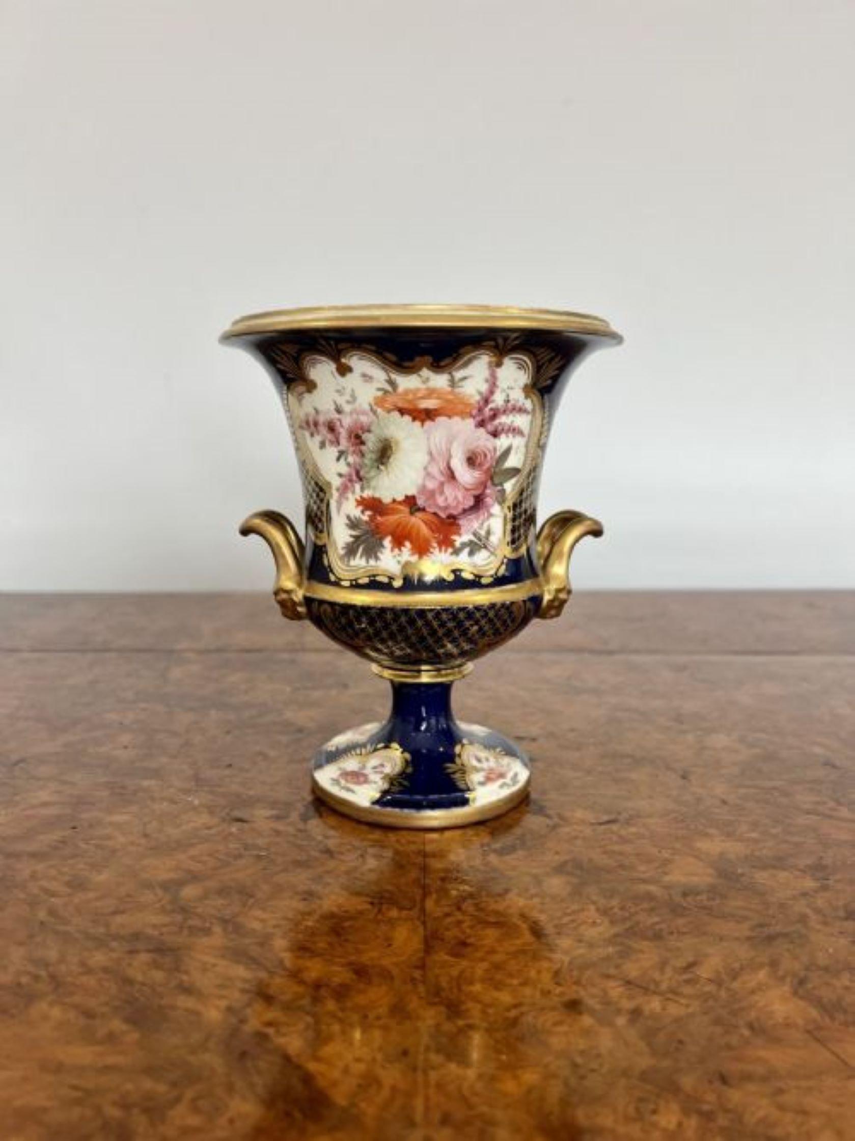 Fine quality early 19th Century Spode vase with outstanding quality gilded decoration, hand painted flowers in wonderful pink, red, white and orange colours on a blue background, having two carrying handles to the sides standing on a circular base.