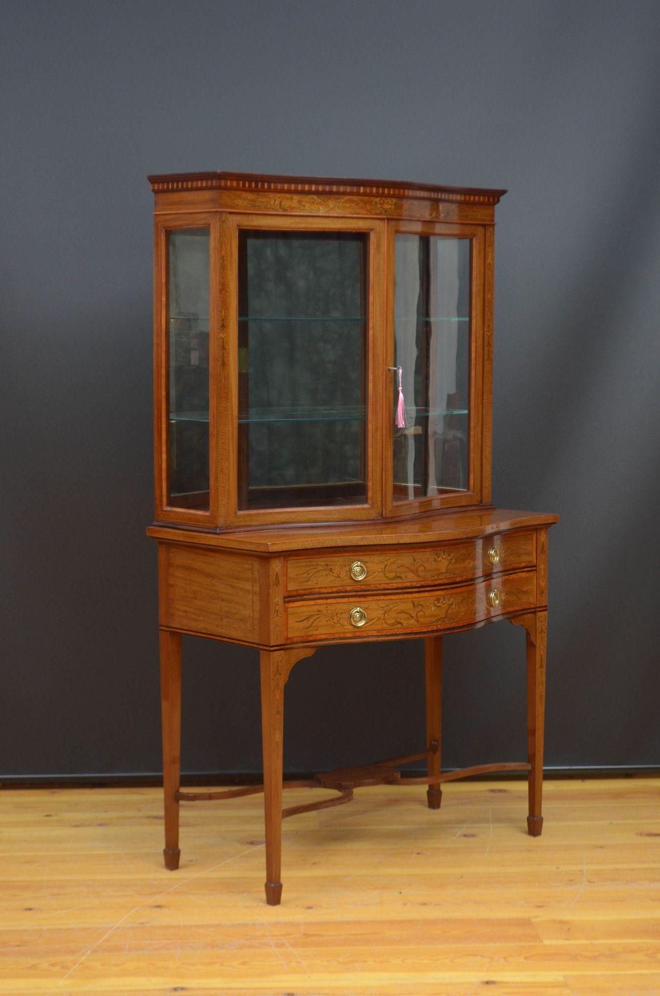 Sn5504 Fine quality Edwardian mahogany and inlaid vitrine of serpentine design, having polished top with dentil inlaid moulding above floral inlaid frieze and a pair of glazed door fitted with original working lock and a key and enclosing two