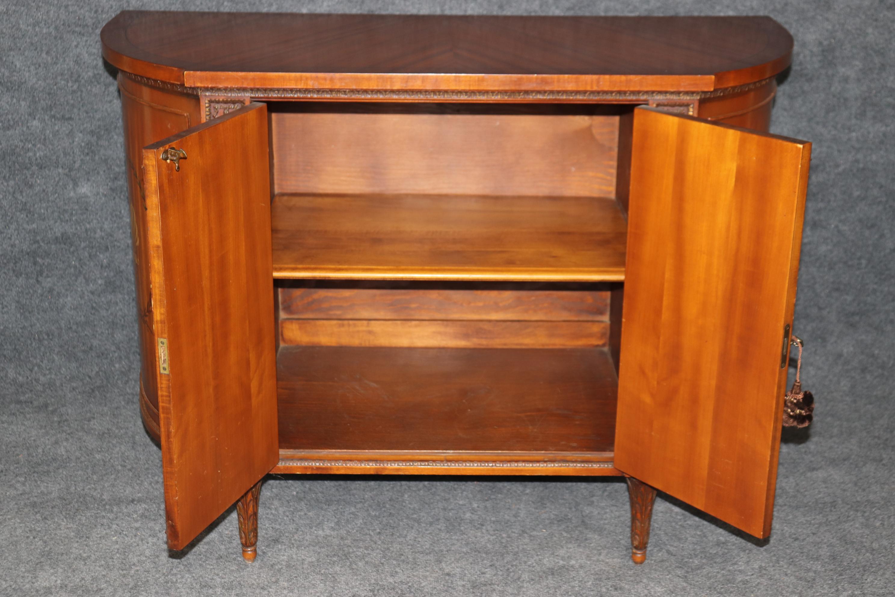 This is a gorgeous, entirely original English-made Adams paint decorated buffet. The case is made of striking satinwood with carved grapes and grape leaves and beautiful anthemia painted stylized leaves and flowers. The condition is original antique