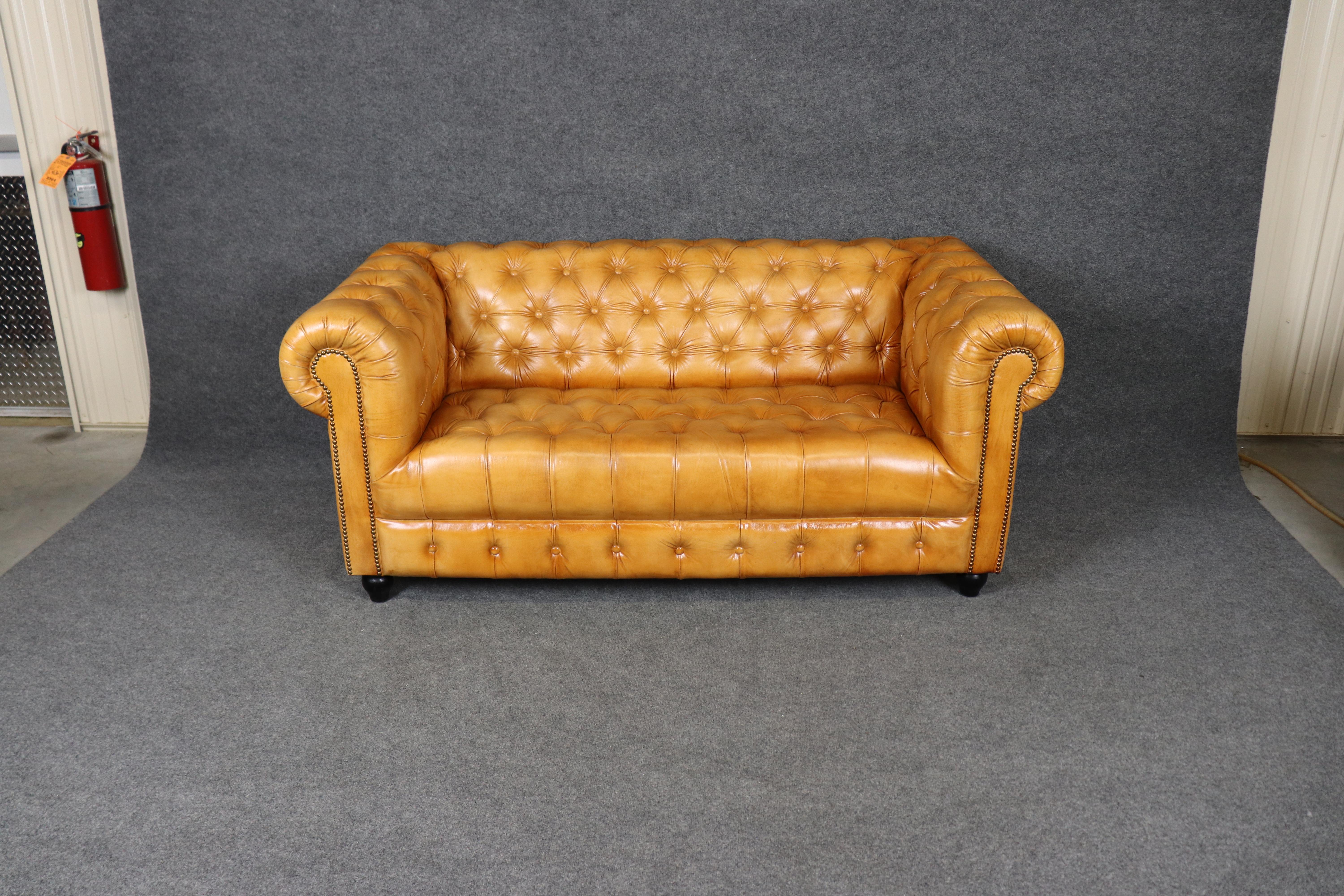 Dieses außergewöhnliche englische 71-Zoll-Chesterfield-Sofa ist mit einem reichen karamellfarbenen Leder bezogen, das zeitlose Raffinesse ausstrahlt. In klassischer Tradition gefertigt, zeichnet er sich durch tiefe Tuftings entlang der Rückenlehne,