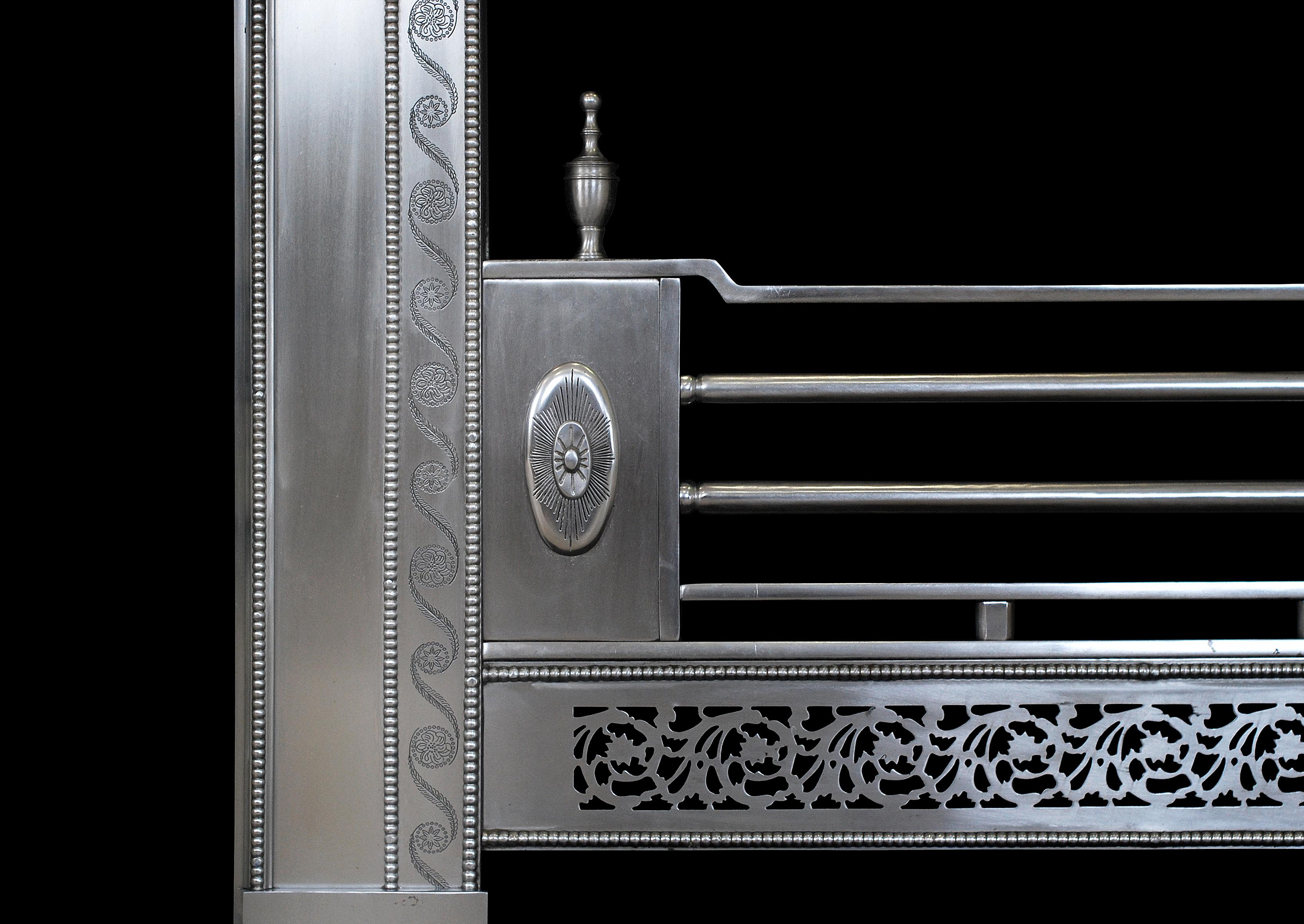 A quality George III style steel register grate. The frame with finely engraved scrolled leaf and rosette detailing. The centre panel with engraved swags and scrollwork with cut patera to centre. The pierced running fret with beaded moulding. Steel