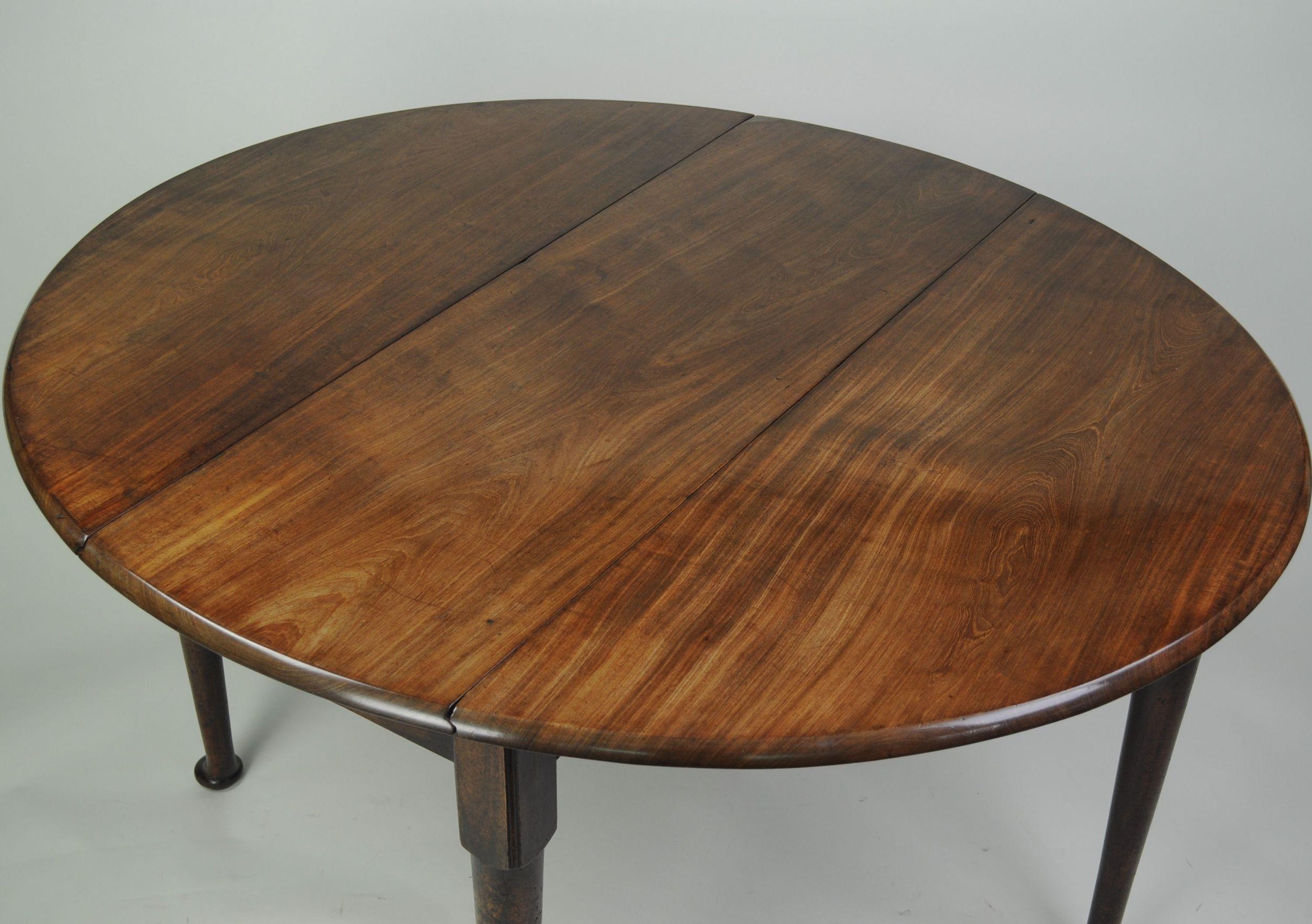 A fine quality mid eighteenth century figured mahogany oval drop-leaf dining table with excellent figured top and good colour. The oval top with two drop-leaves with rounded edges, supported on four turned legs with pad feet. (two of the legs hing