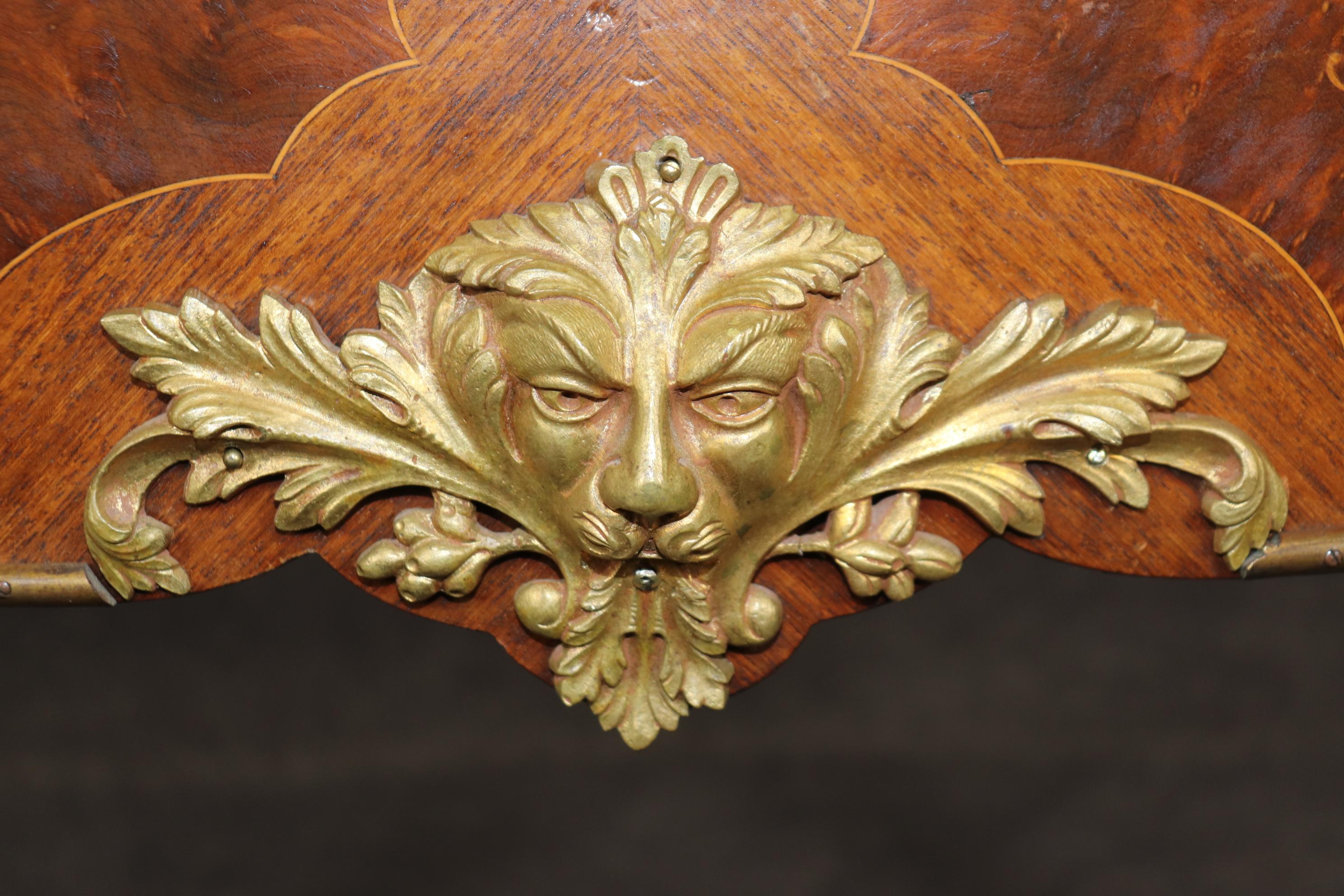 This is a spectacular burled walnut, bronze mounted, and satinwood inlaid center table that is just incredibly adorned with majestic inlay of flowers, meticulously and crisply inlaid and features lion face masques of solid bronze of the finest