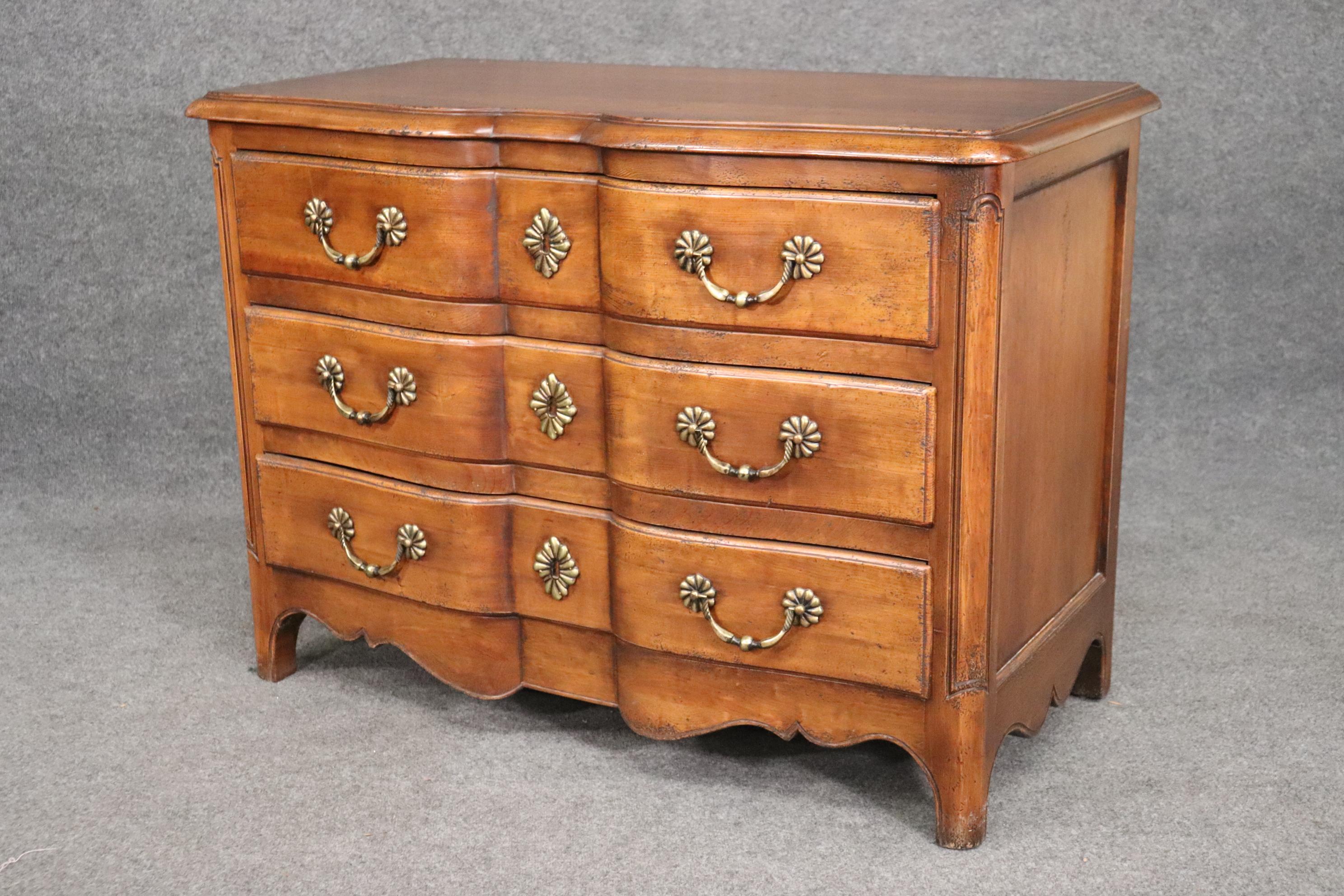 This is a beautiful high quality commode in the French country style. Made of walnut and featuring beautiful brass hardware, this commode can be painted or used as is. The commode measures 46 wide x 34 tall x 23 deep and dates to the 1950s era. The