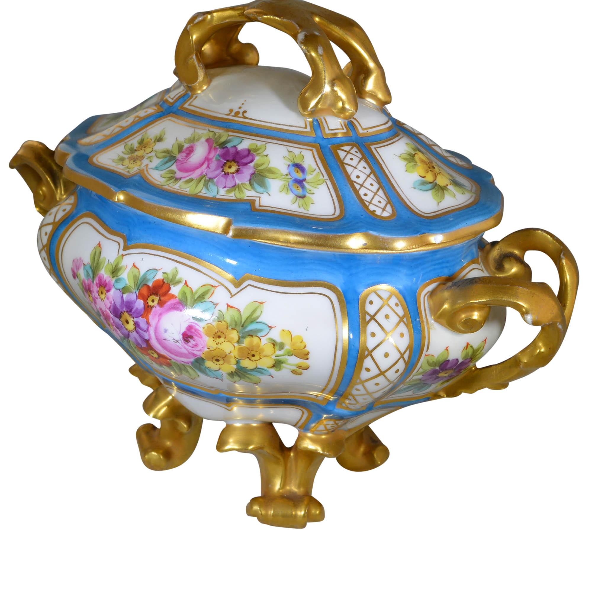 This is a fine quality 19th century French antique Sèvres porcelain gravy tureen with fantastic hand painted panels, with gilt decoration. Uniquely designed with four feet. Lovely blue base color on white porcelain. The floral panels are primarily