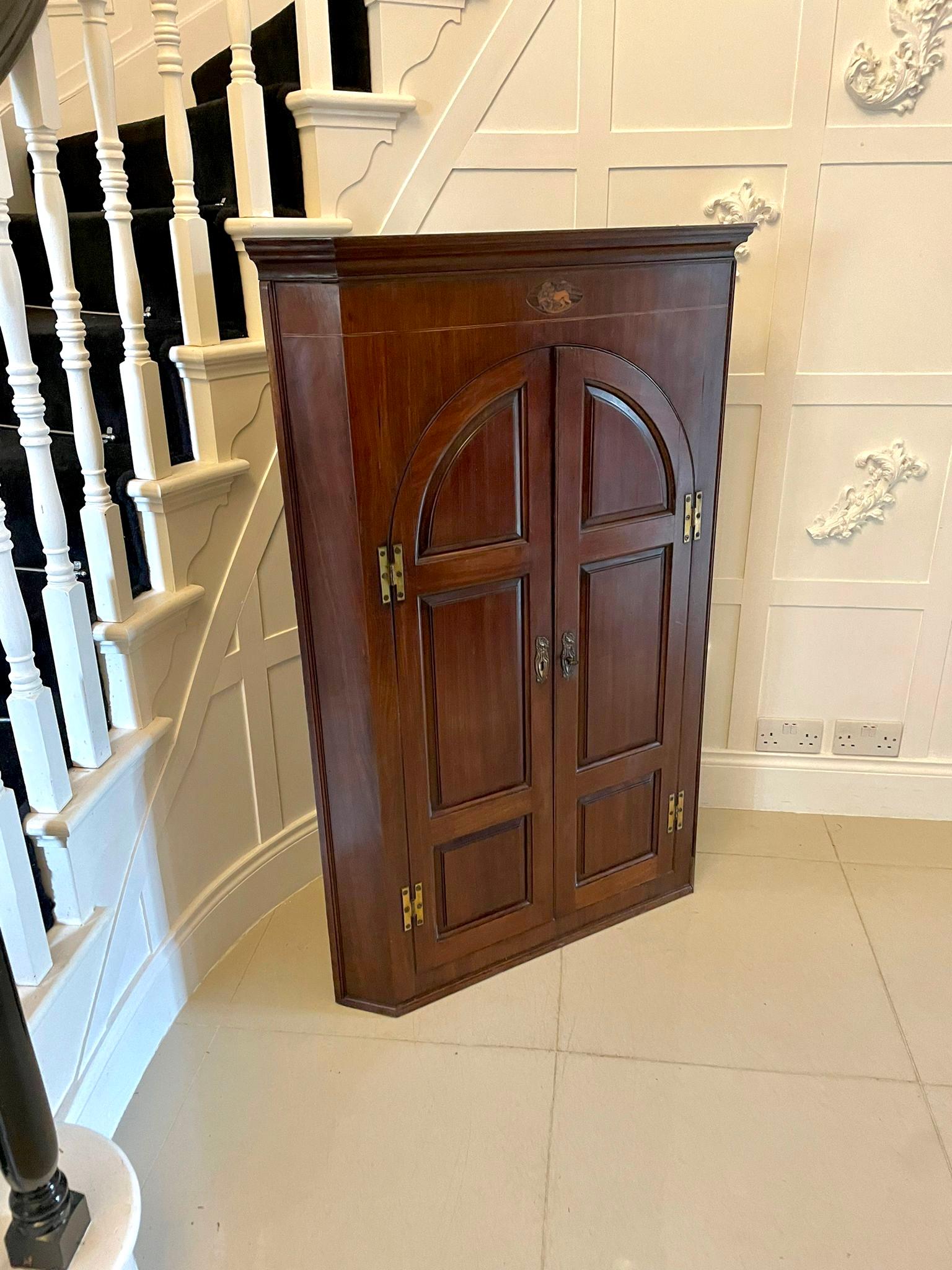 fine quality George III antique mahogany hanging corner cabinet with a charming shaped cornice above two arched panelled doors with original brass H-hinges and a delightful fitted interior. It comes with the original key.

A splendid example in