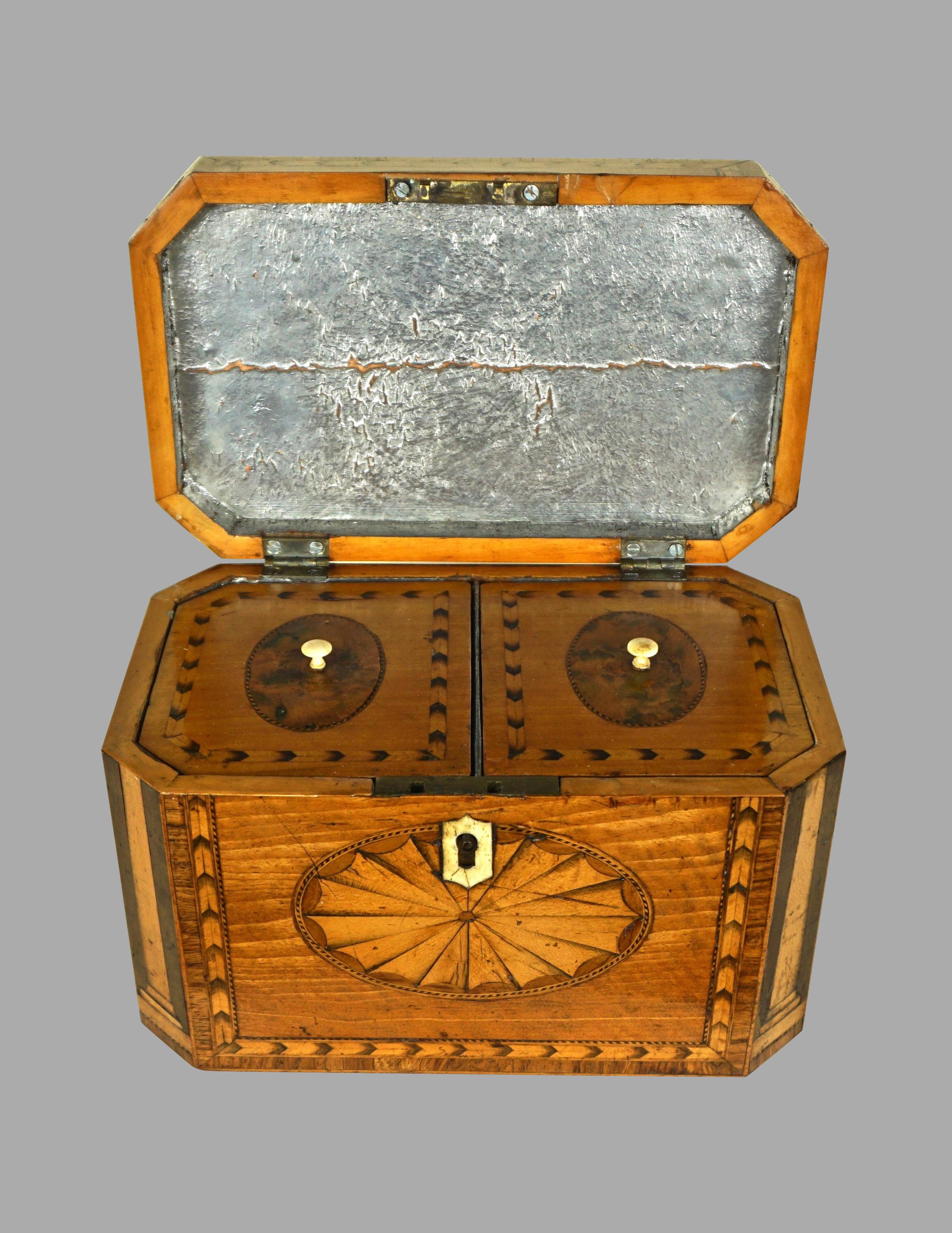 A fine quality Georgian heavily inlaid satinwood octagonal tea caddy, the top with a conch shell and fan design, the front with a shell inlay, the corners decorated with boxwood columns, the sides further inlaid with oval burled panels all with
