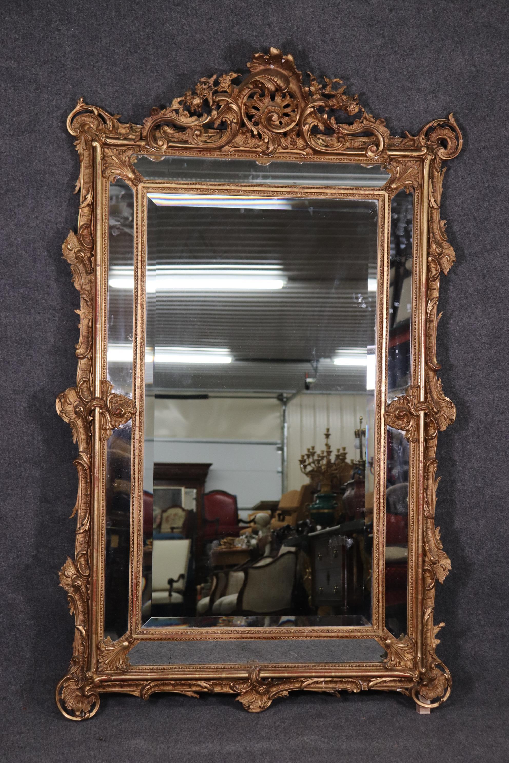 This is a gorgeous mirror with incredibly intricate carving and a beautiful gilded gold finish. The mirror dates to the 1920s and is 52 tall x 31 wide x 2 inches deep.