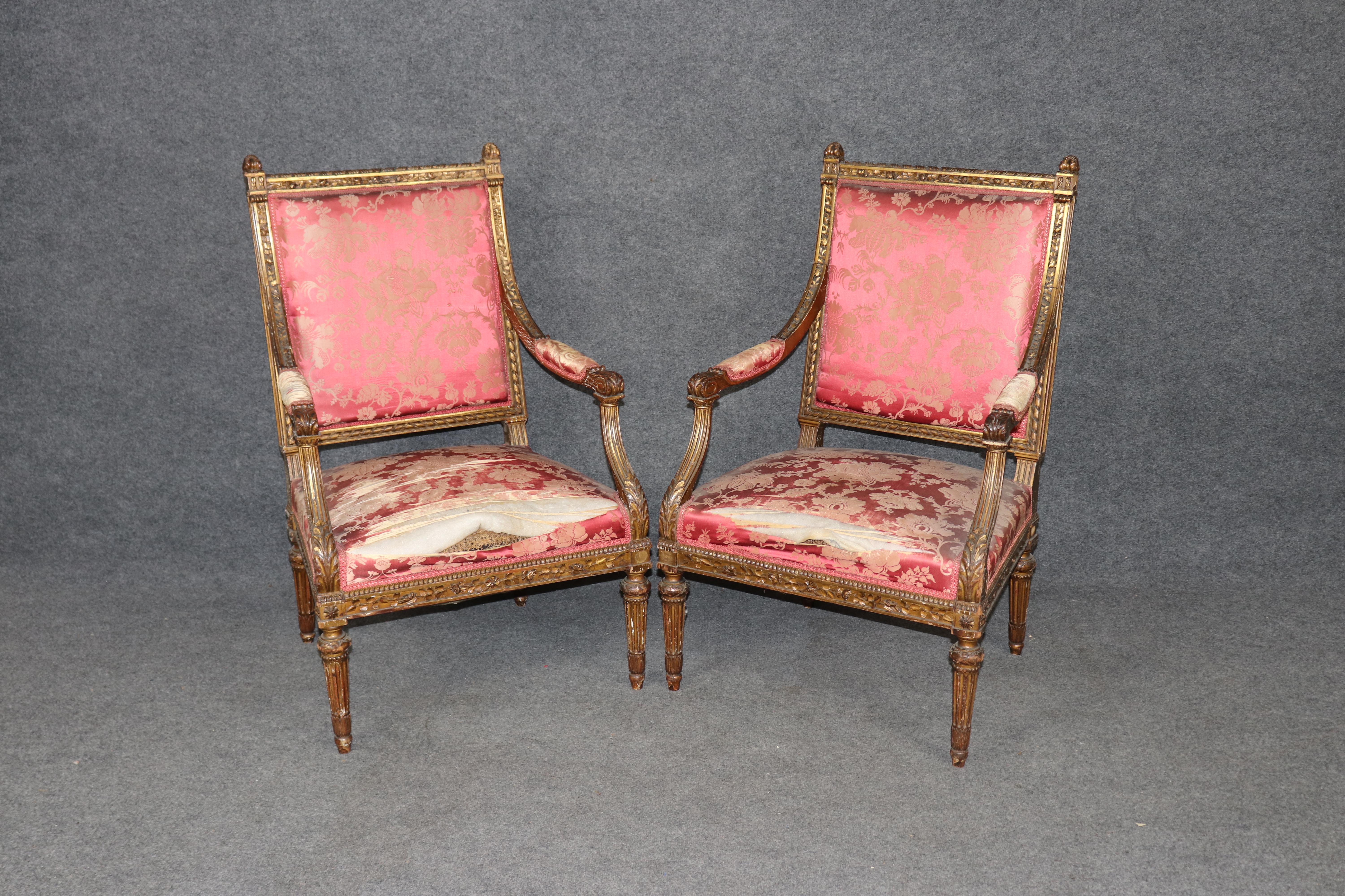 Questa magnifica coppia di antiche poltrone dorate francesi Luigi XVI, risalenti al 1870, incarna l'eleganza senza tempo del design neoclassico. Realizzata con un'eccezionale attenzione ai dettagli, ogni sedia presenta una struttura in legno dorato