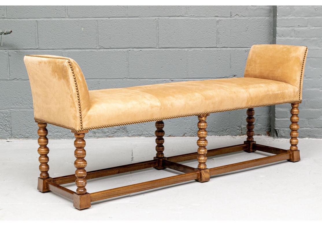 A very well-made and solid feeling Hall Bench in very good condition. With six carved Bobbin turned legs having strong graining and with incised lines and flat stretchers all around and one in the center. The high sides and seat upholstered in fine