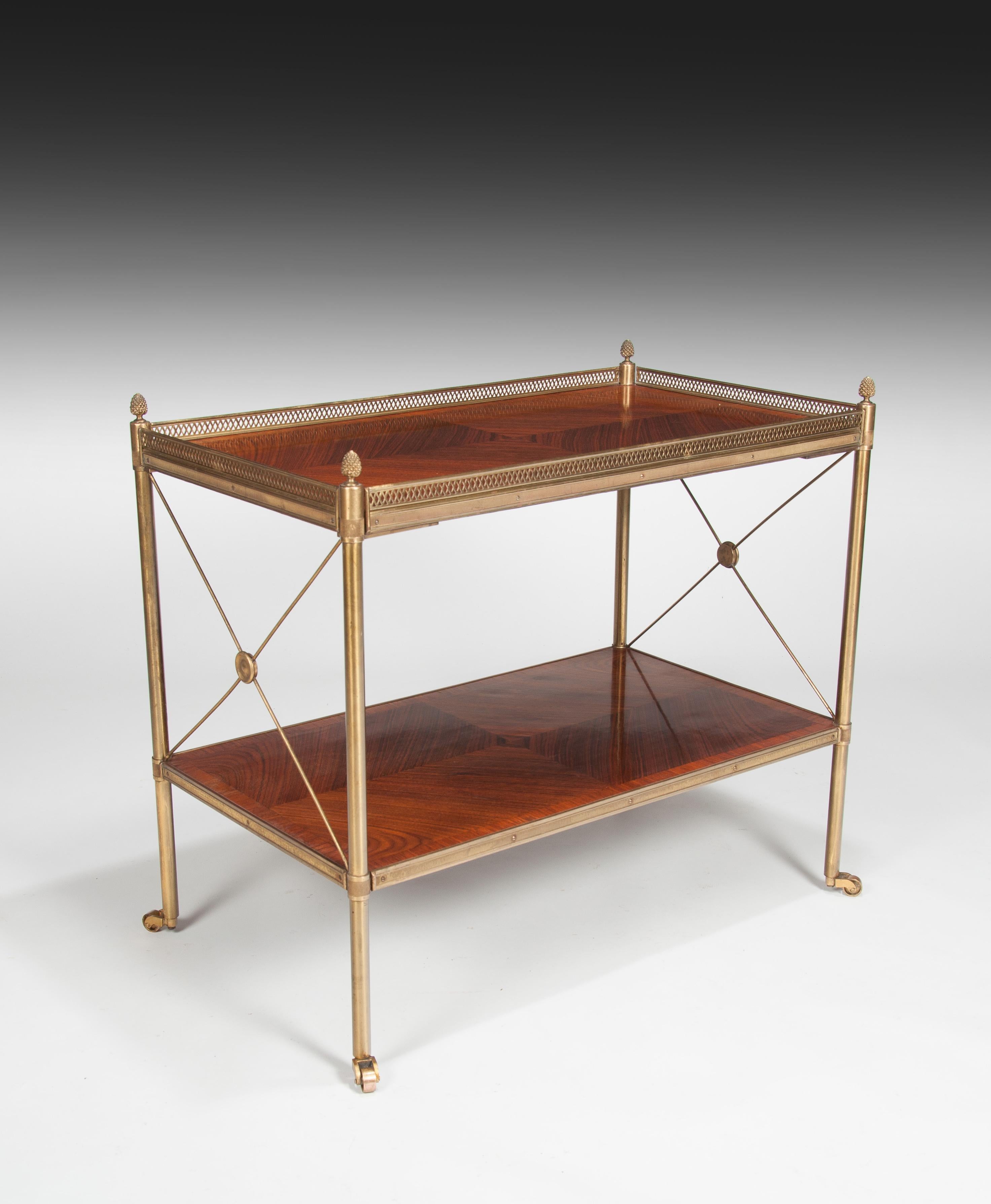 A very fine quality Kingwood and lacquered brass two-tier etagere.

France, circa 1920.

The rectangular top quarter veneered in Kingwood with a crossbanded tulipwood border enclosed with a pierced brass gallery, held by four turned supports