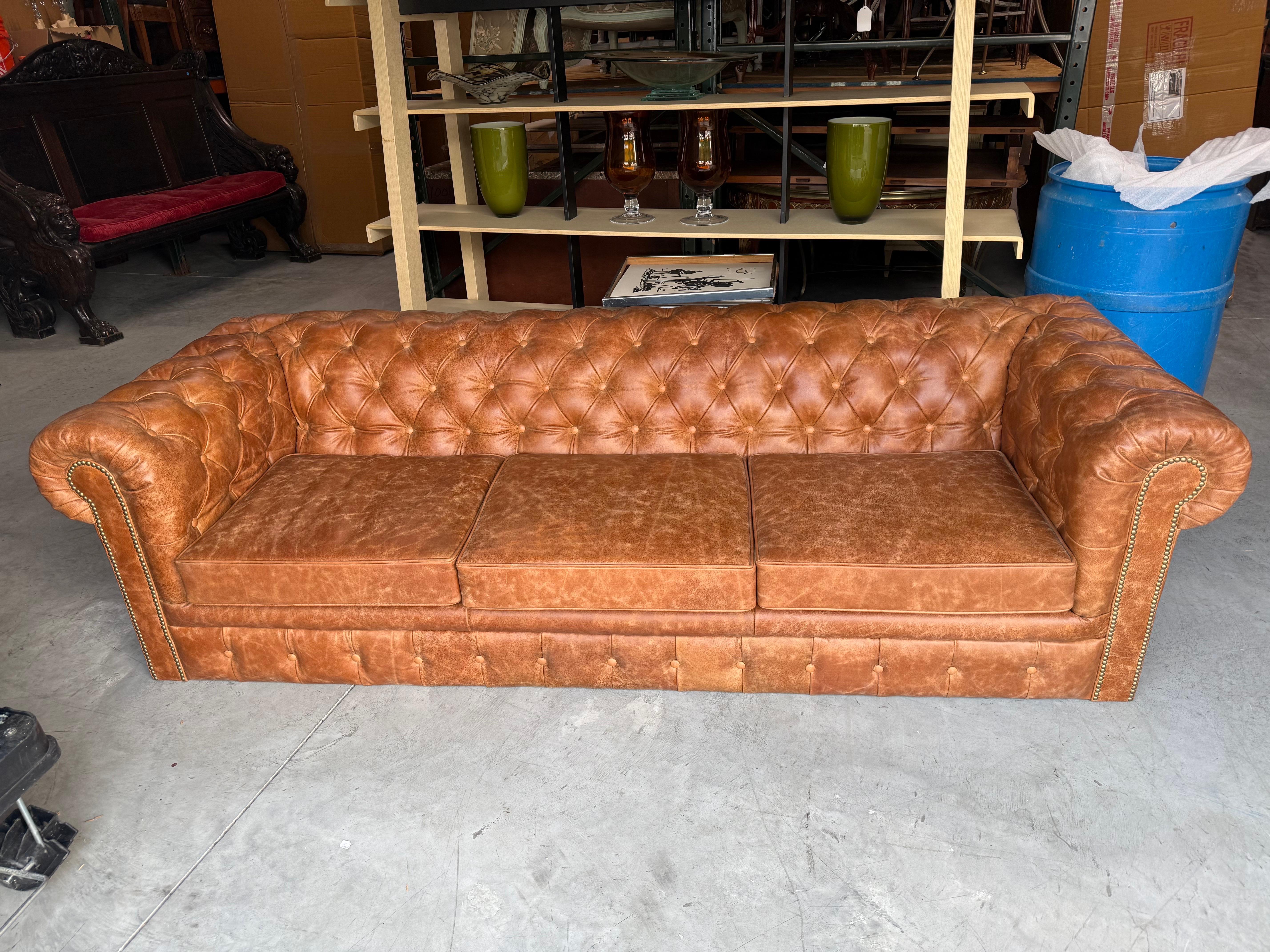 

Dieses beeindruckende 95-Zoll-Chesterfield-Sofa zeigt die dauerhafte Eleganz des klassischen englischen Designs. Das Sofa ist mit geschmeidigem, hellbraunem Echtleder gepolstert und verfügt über die ikonischen tiefen Knöpfe an Rückenlehne und