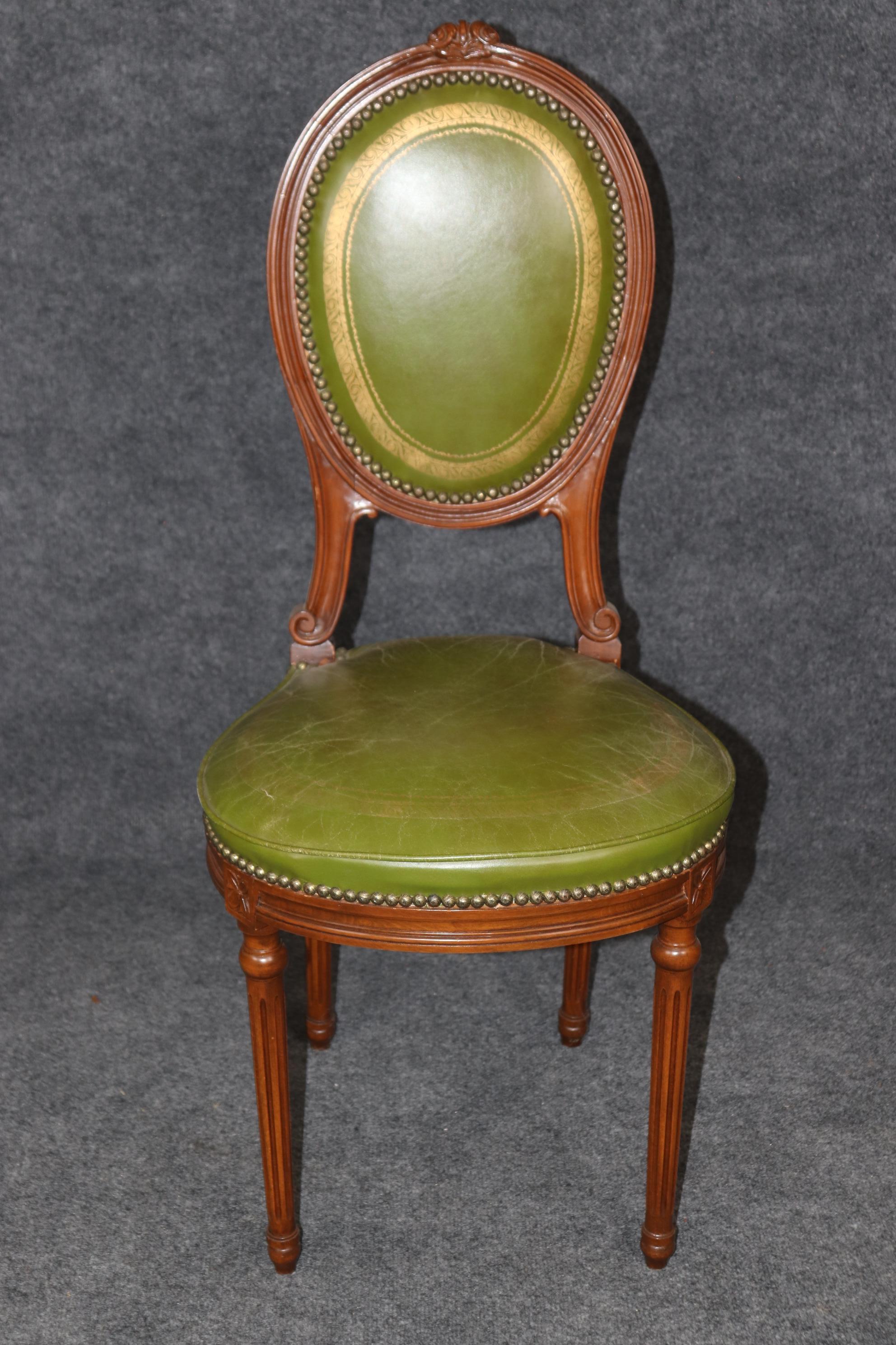 This is a superb French 1920s era gold tooled leather embossed ladies' vanity chair or boudoir chair in gorgeous walnut. The frame is meticulously carved and in very good condition with a naturally time-worn distressed leather seating surface. The