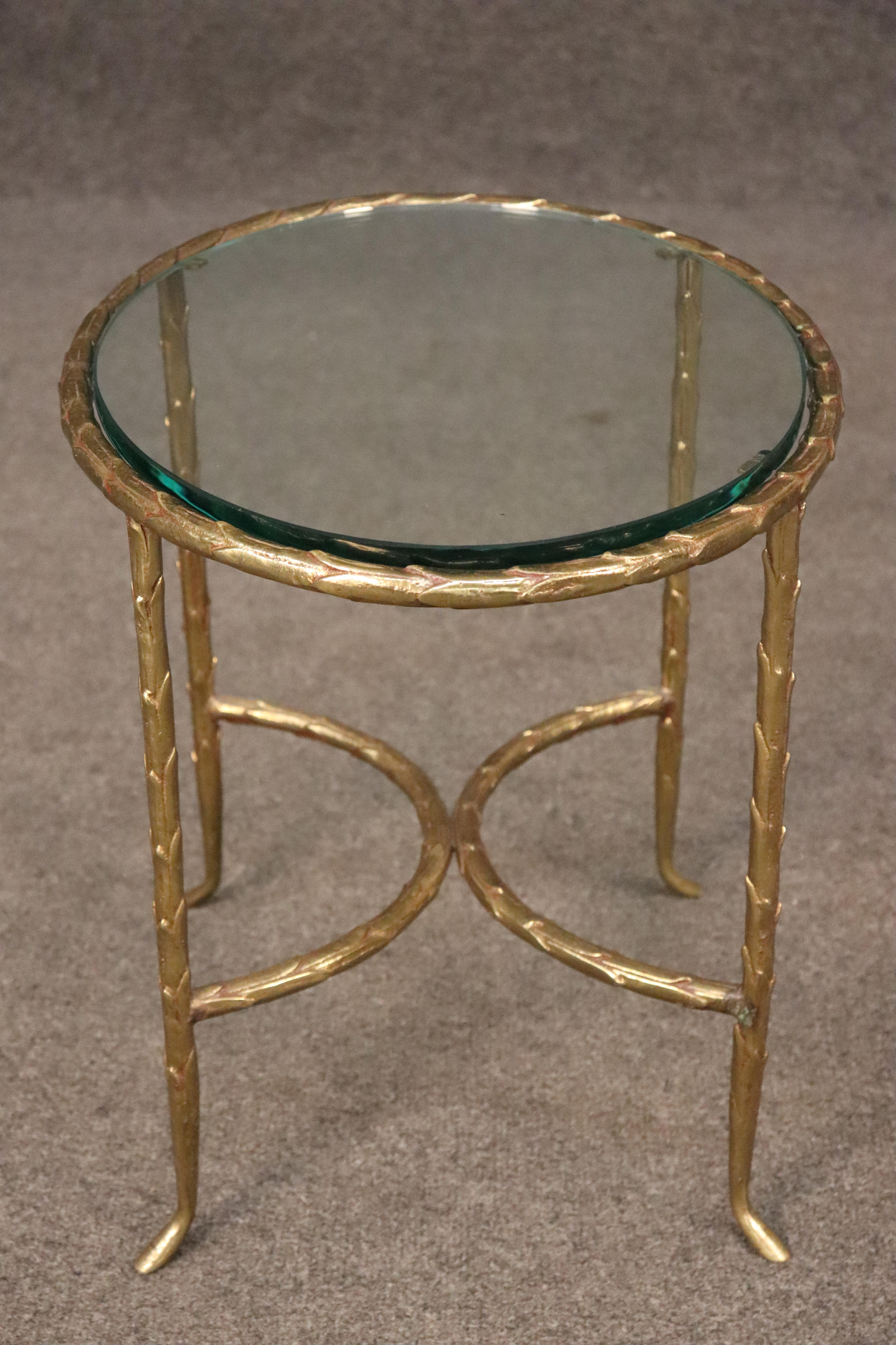 Il s'agit d'un superbe motif emblématique de la célèbre Maison Bagues, qui utilise régulièrement des feuilles d'olivier dans ses tables en bronze moulé. Le verre a ce bord vert très épais que nous aimons tous. La table est en bon état avec des