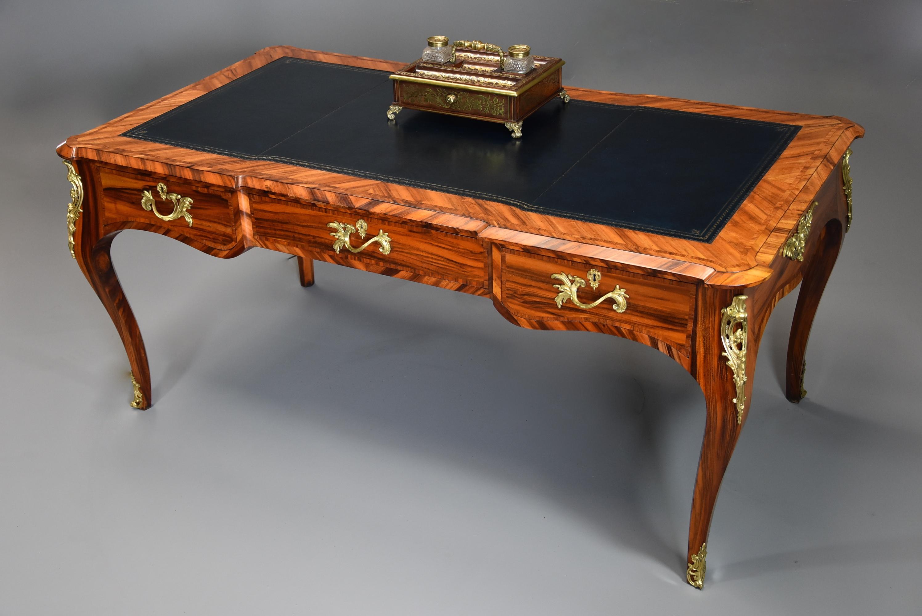 A fine quality mid-19th century (1840) Goncalo alves freestanding bureau plat in the French style of good proportions, attributed to Gillows of Lancaster.

This bureau plat consists of a dark blue tooled leather top with goncalo alves banding with a