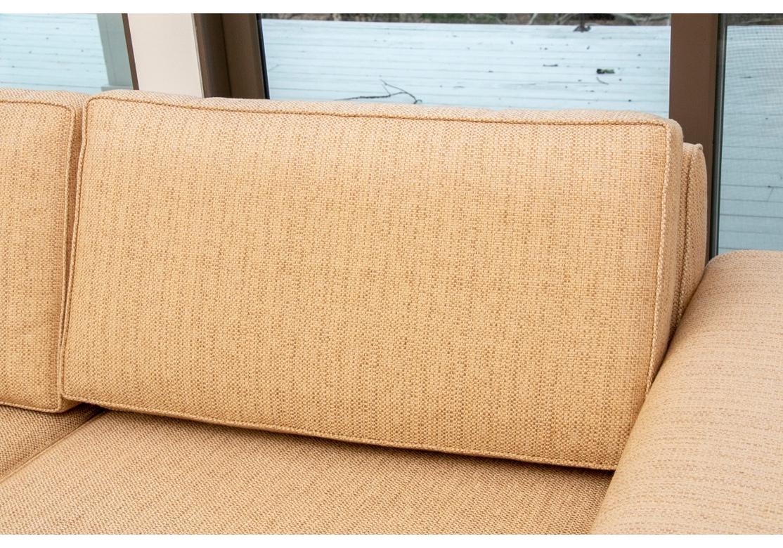 A modern sofa with contemporary lines upholstered in a textured natural weave. The sofa is very well made and comfortable. The upholstery is flawlessly applied, and the arms feature an in curved arm. Dark stained wooden block foot. Quality foam