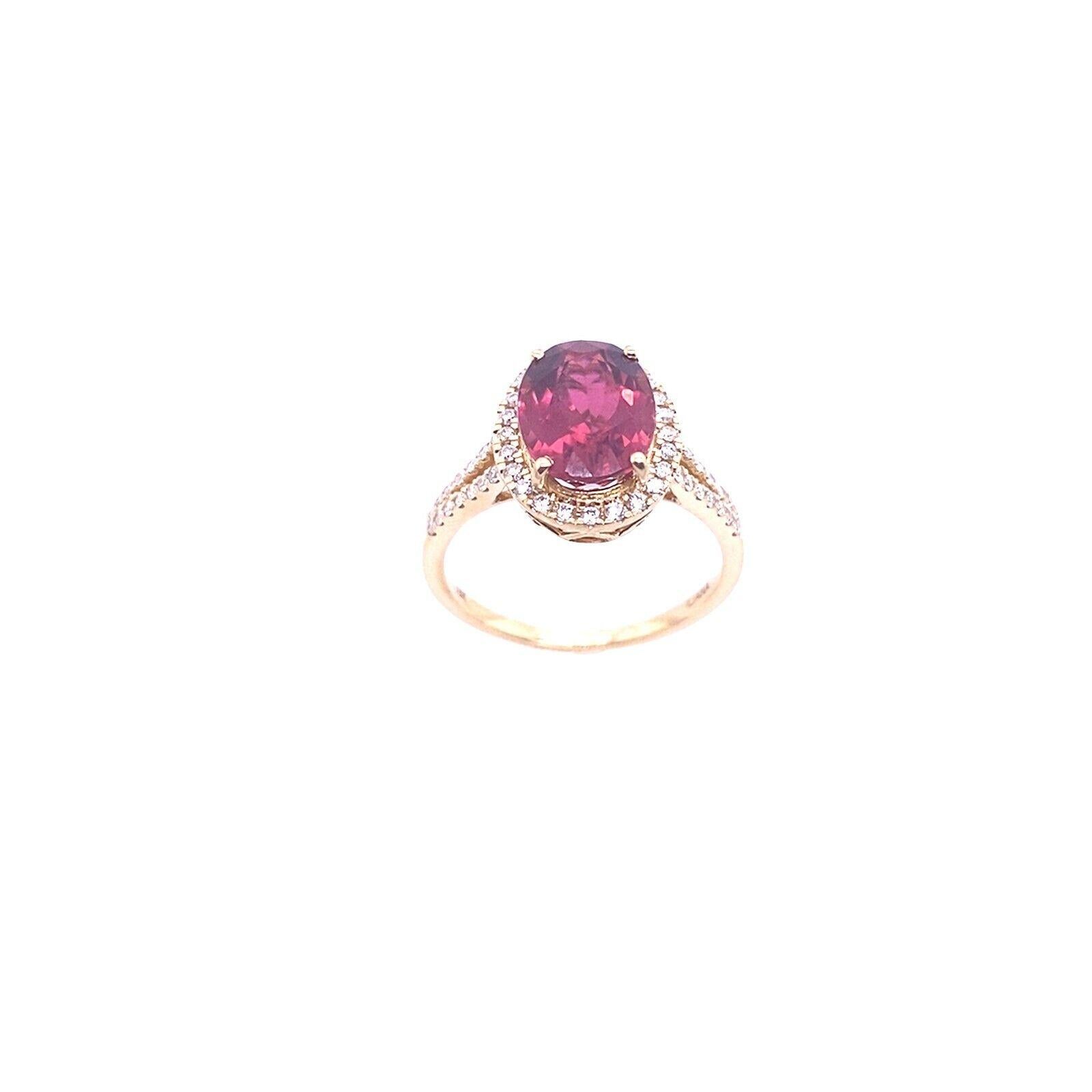 Cette bague étonnante et élégante est ornée d'une Rubellite ovale de 3,0ct entourée de 0,25ct de diamants et sertie dans un anneau en or jaune 18ct à deux branches. Le design simple de cette bague en fait l'option parfaite pour une occasion spéciale