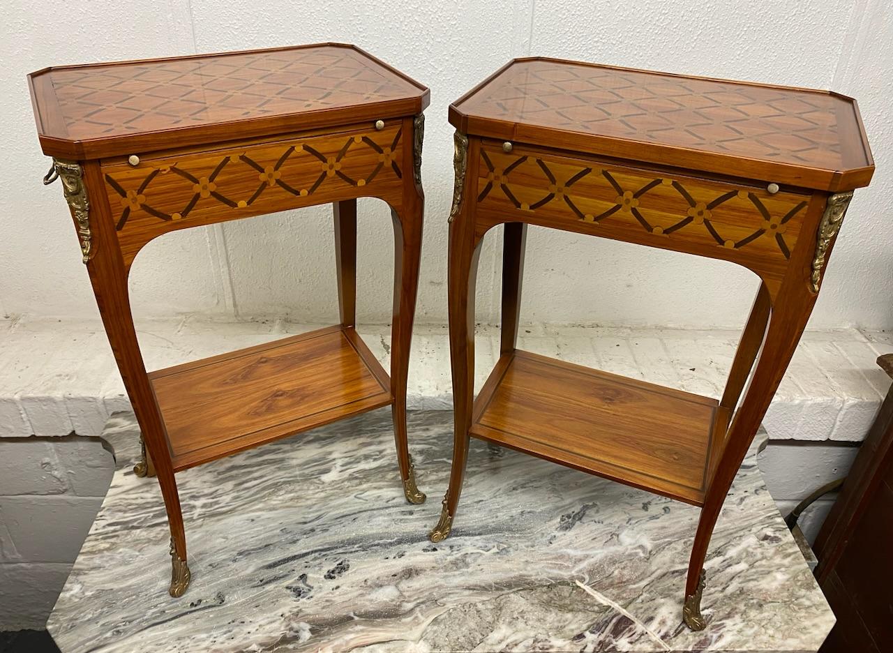 A very good quality pretty pair of French Bedside Lamp Tables. Satinwood and Kingwood with floral marquetry to the top and sides. Excellent quality ormolu mounts and handles. Each has a single drawer and and a slide. 
We have re finished these to a