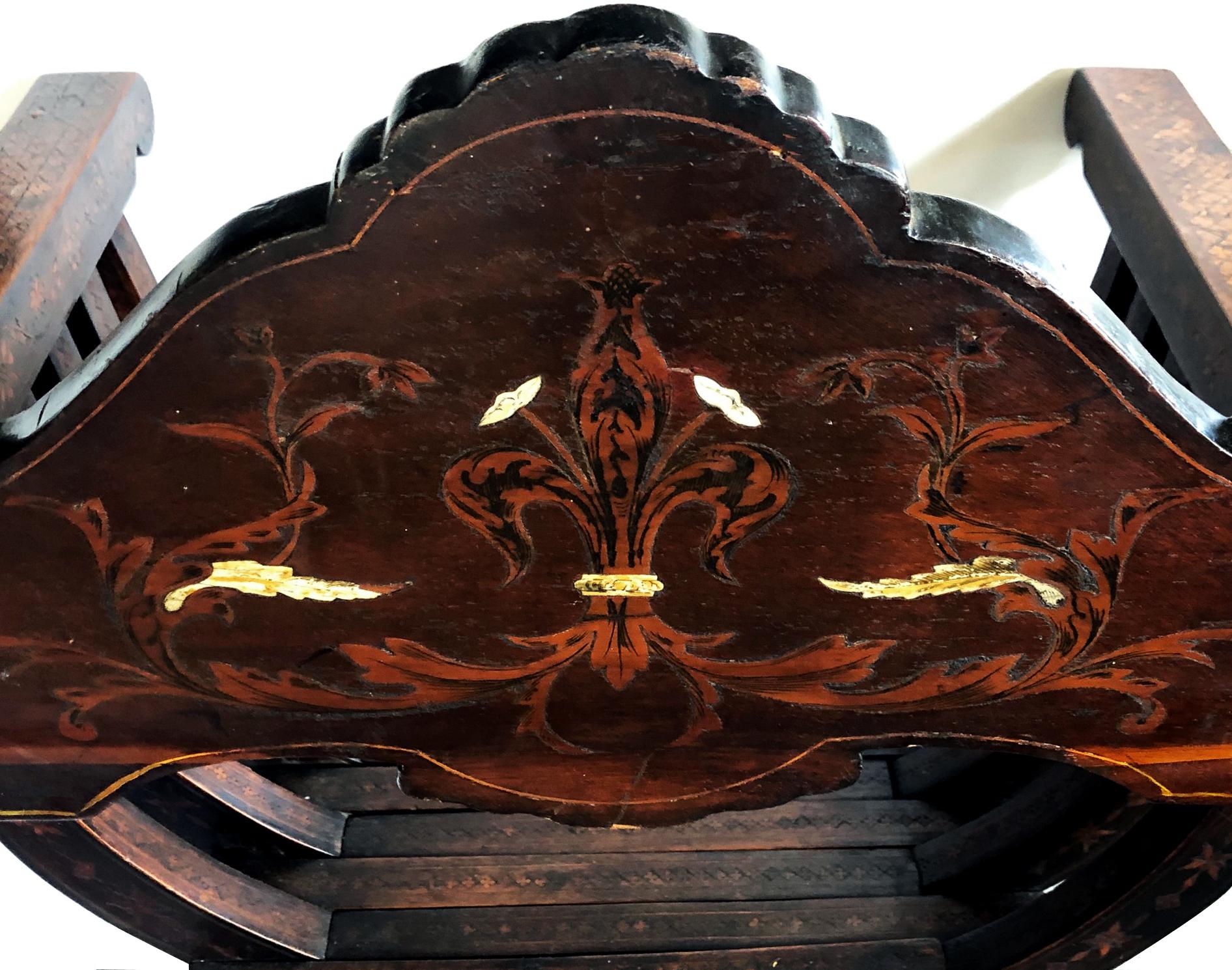 A fine quality pair of Florentine walnut and bone inlaid Savonarola x-form chairs with Medici crest; each stunning chair with shaped back crest rail with inlaid royal heraldry centering the Medici coat of arms; the whole with geometric and marquetry