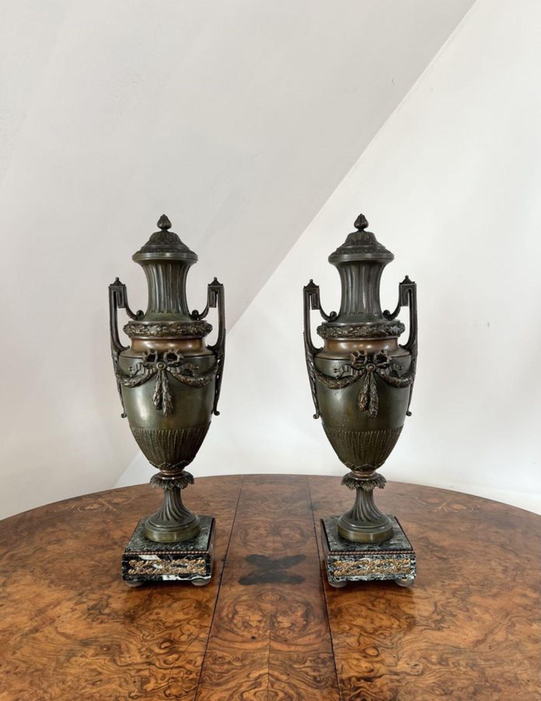 Fine quality pair of large antique Victorian bronze urns have a pair of fine quality antique Victorian bronze urns of a classical shape with twin handles, decorated with a bow to the front raised on marble bases.

D. 1860