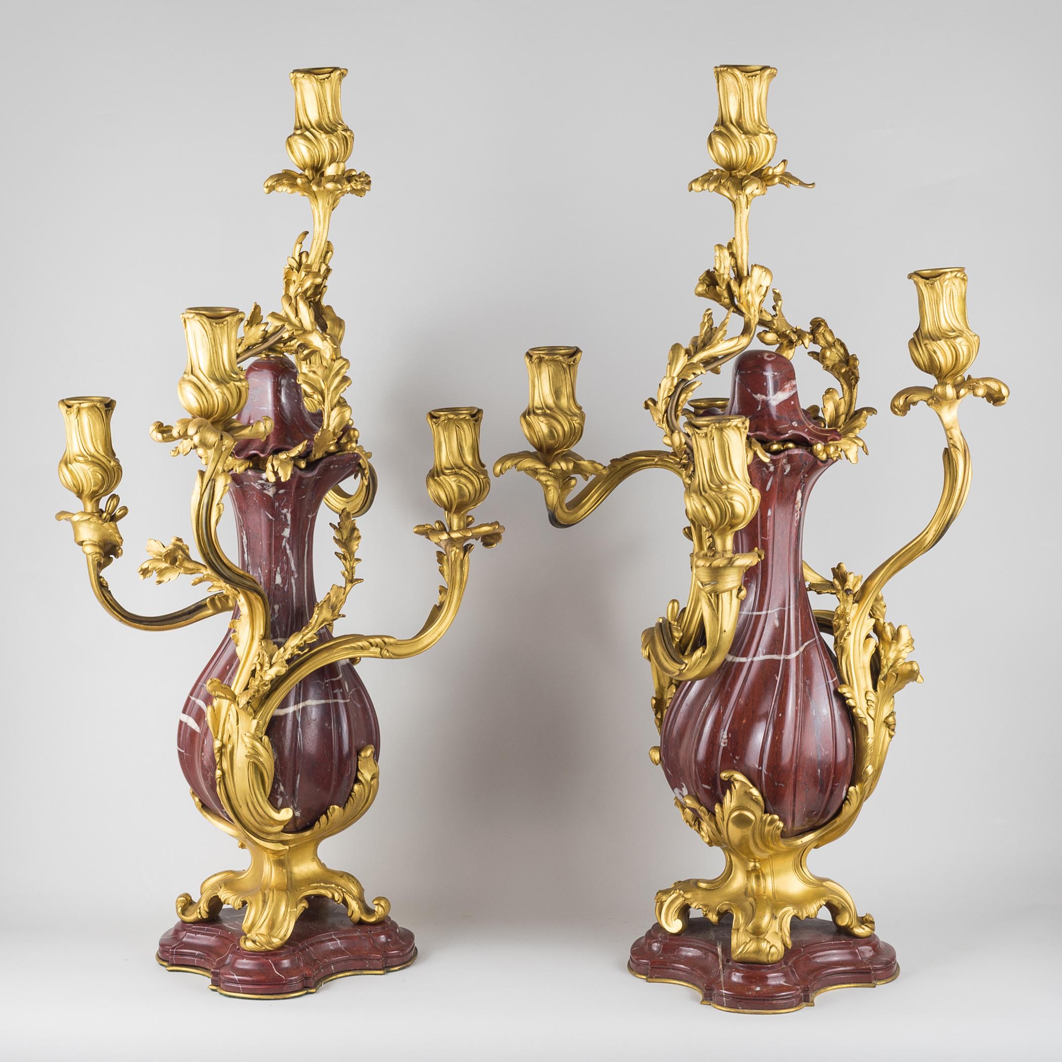 Paire de candélabres à cinq lumières de style Louis XV en bronze doré et marbre rouge de la fonderie E. Colin & Cie Paris, de forme balustre entrelacée d'ornements feuillagés sur les bras en volute, reposant sur des pieds façonnés et une plinthe