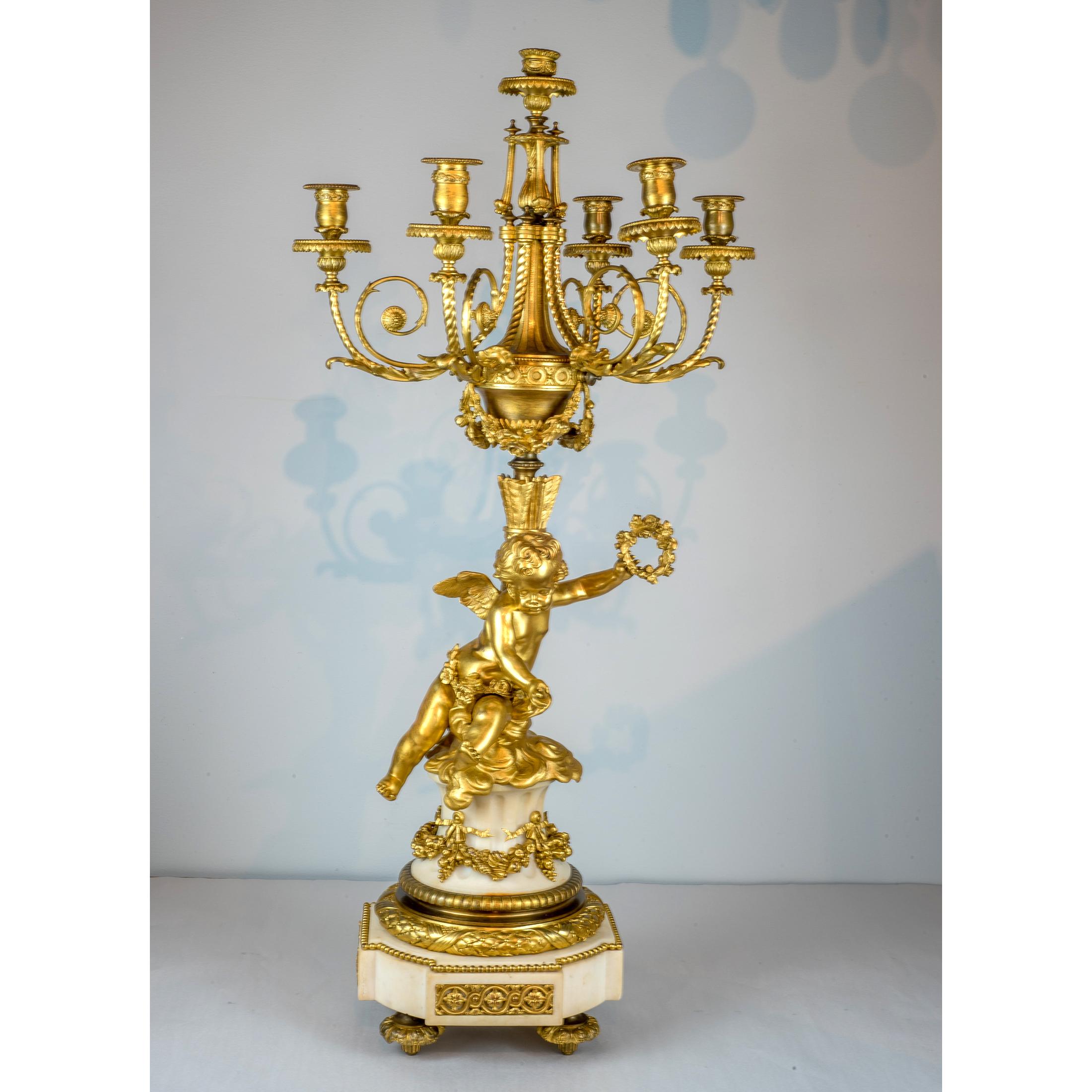 The fine quality pair of gilt bronze and marble candelabras with one cherub holding a garland and the other holding a torch.

Origin: French
Date: 19th century
Dimension: 35 in. x 16 3/4 in.