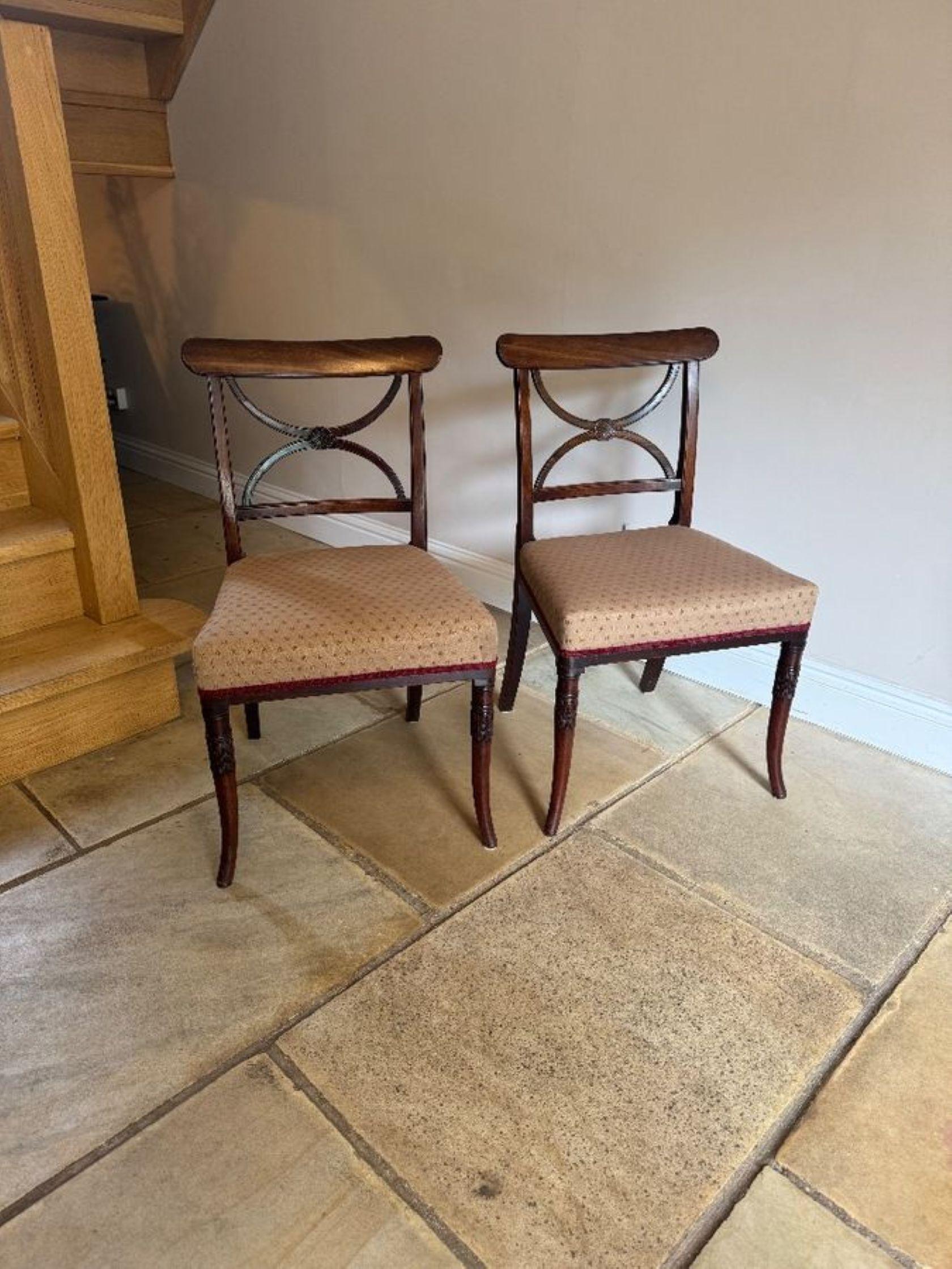 Fine quality set of four antique Regency mahogany dining chairs, having a quality set of four antique Regency mahogany dining chairs each with an elegant X-shaped splat back with a central carved rosette medallion above an upholstered seat in a
