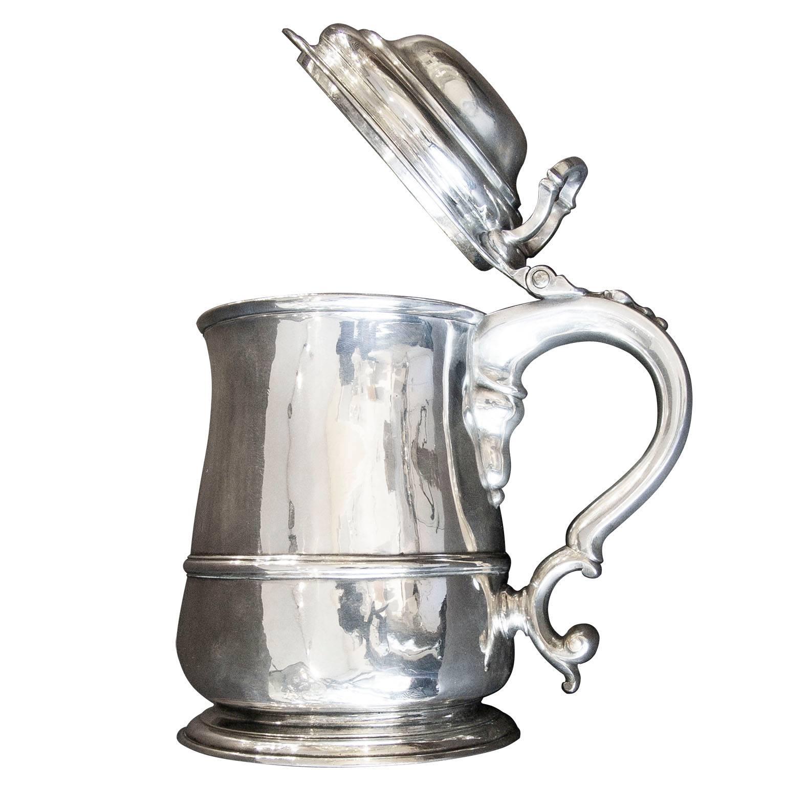 A fine quality sterling silver George II covered / lidded belly quart tankard. London made.

A heavier than usual antique George II sterling silver lidded tankard. This silver Georgian (George II) quart tankard has an impressive domed hinged lid