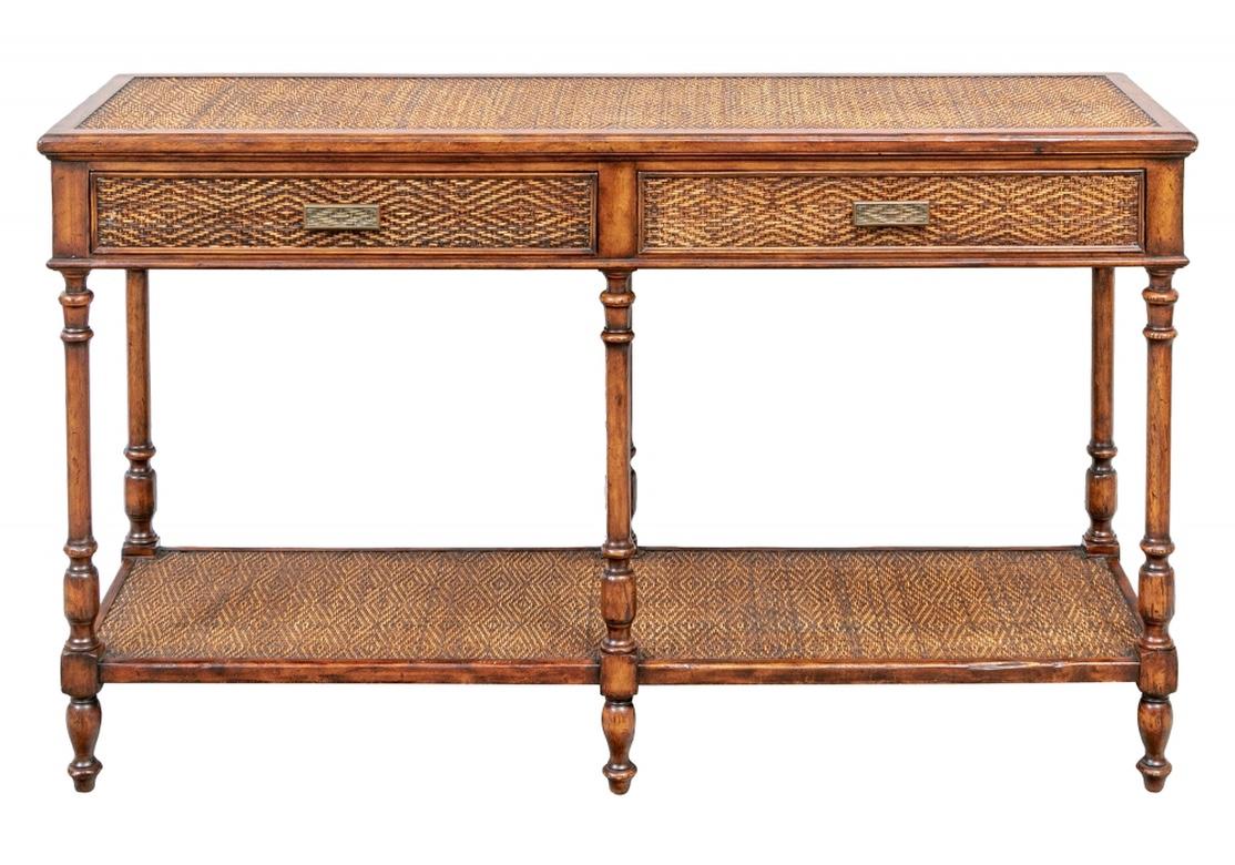 A handsome and very well made console or sofa table in rustic style. Fine wood construction, the banded top with a woven panel in a diamond pattern. With matching woven twin apron drawers with cast patinated brass pulls in a complementary woven