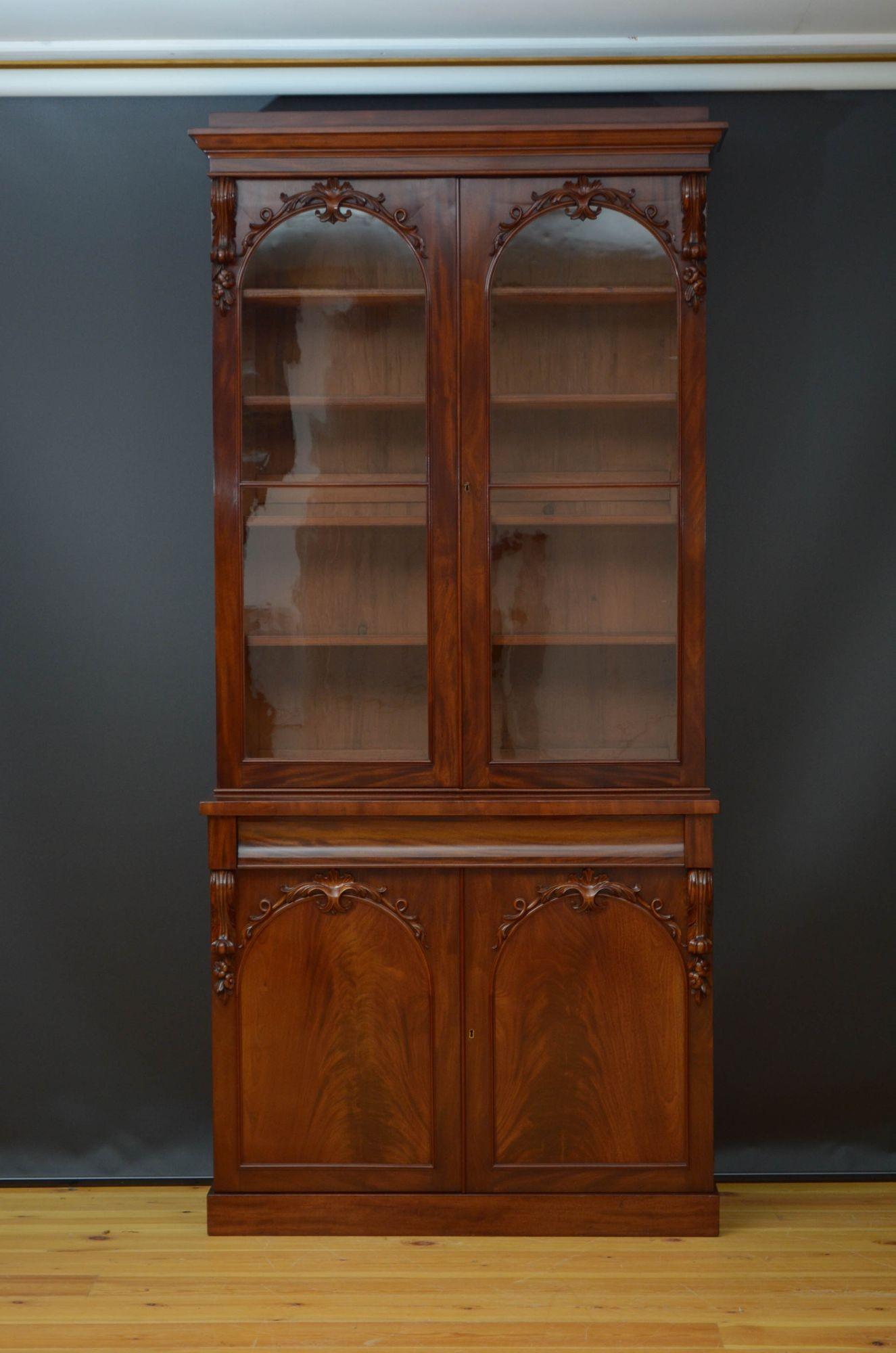 Sn5178 Fine quality and very elegant Victorian mahogany bookcase, having cavetto cornice above a pair of arched, glazed doors with decorative carvings, fitted with original working lock and a key and enclosing four height adjustable shelves, all