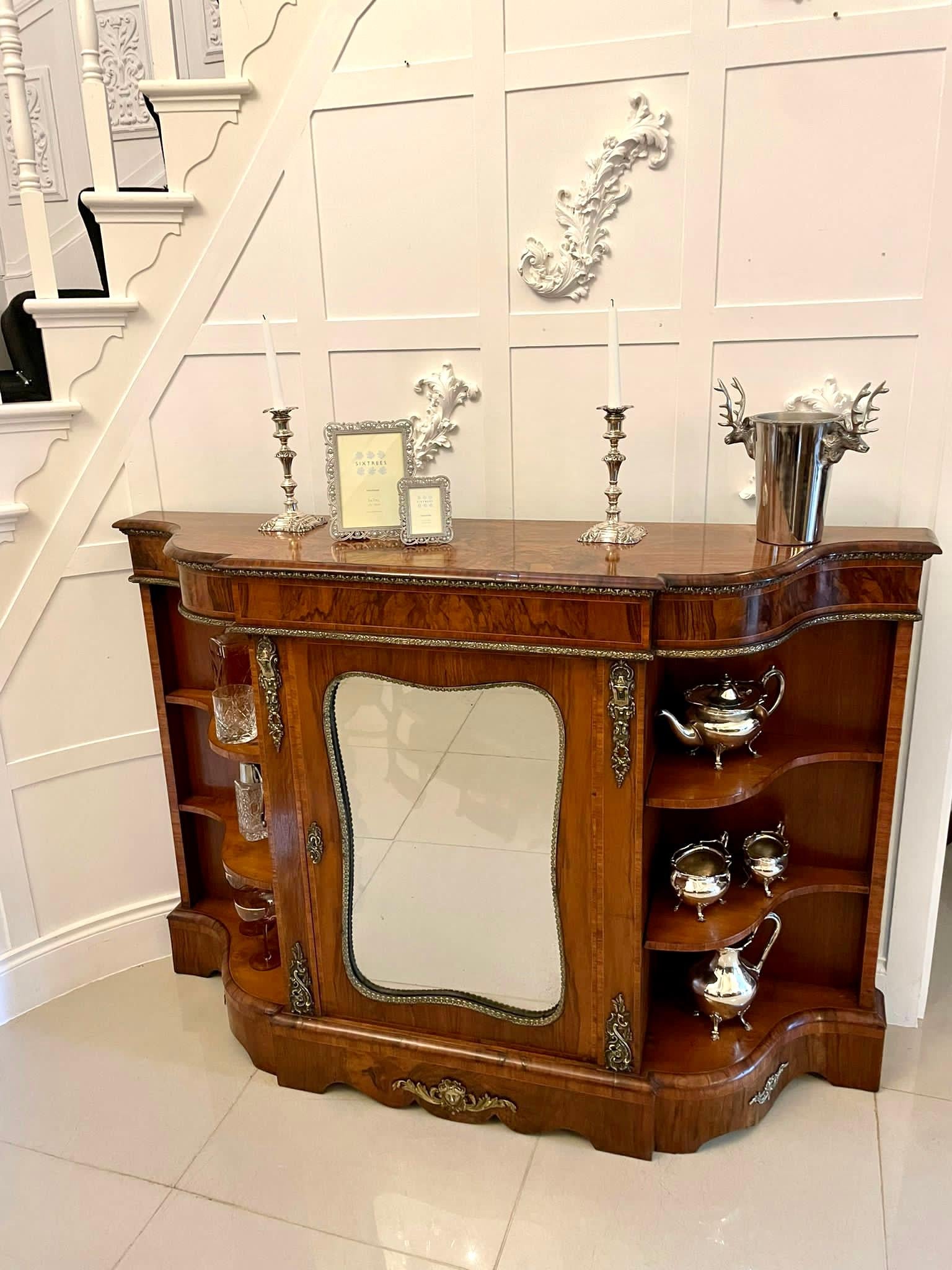 Fine quality Victorian burr walnut credenza with a fabulous quality serpentine shaped top and kingwood crossbanded frieze and beautiful ormolu mounts. The centre door has the original shaped mirror. It boasts wonderful serpentine open ends and