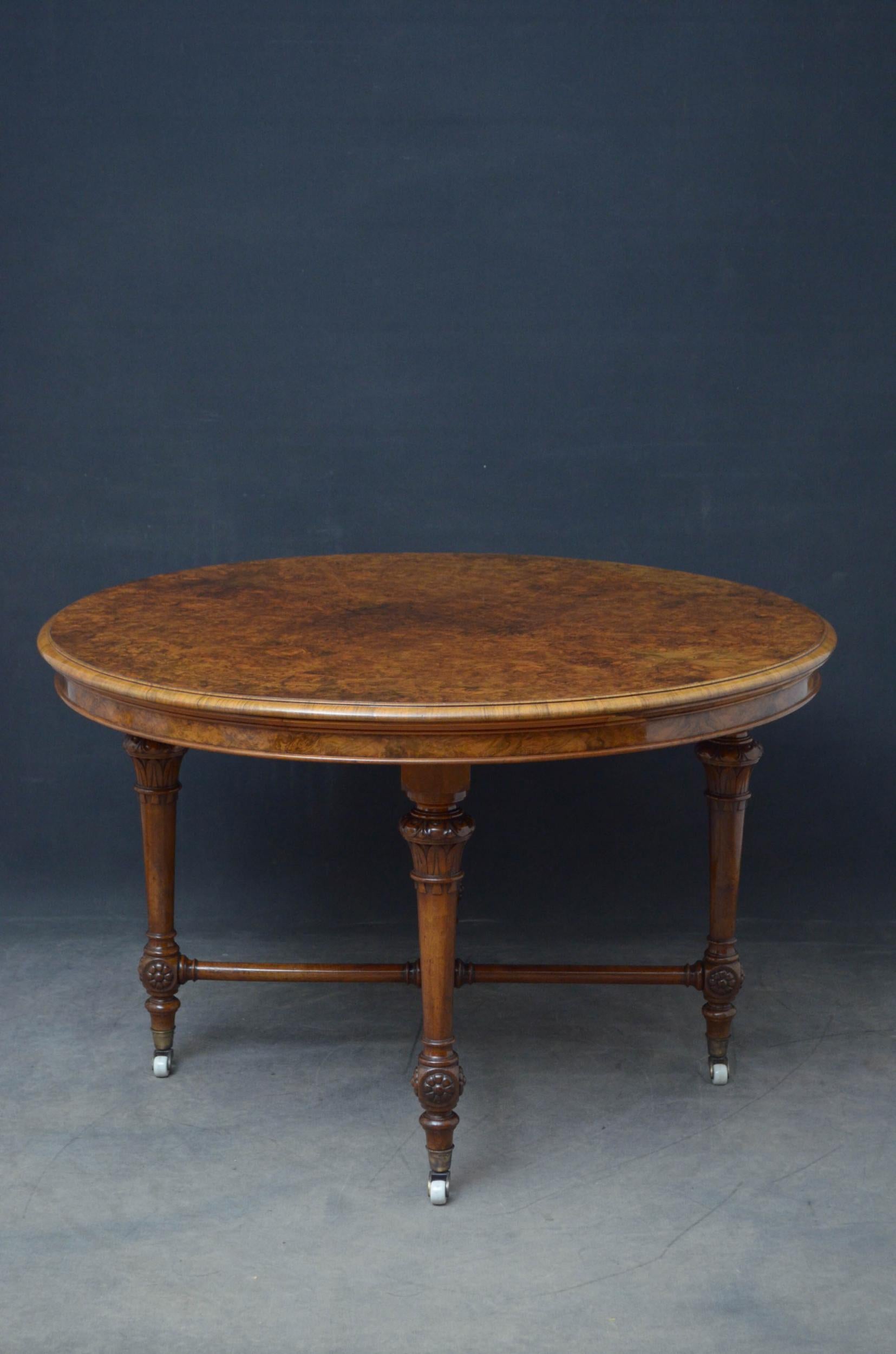 J00 unusual Victorian centre table having a superb burr walnut top with moulded edge above shallow frieze, standing on four turned and tapered finely carved legs terminating in cup castors, all united by turned stretcher with carved finial to