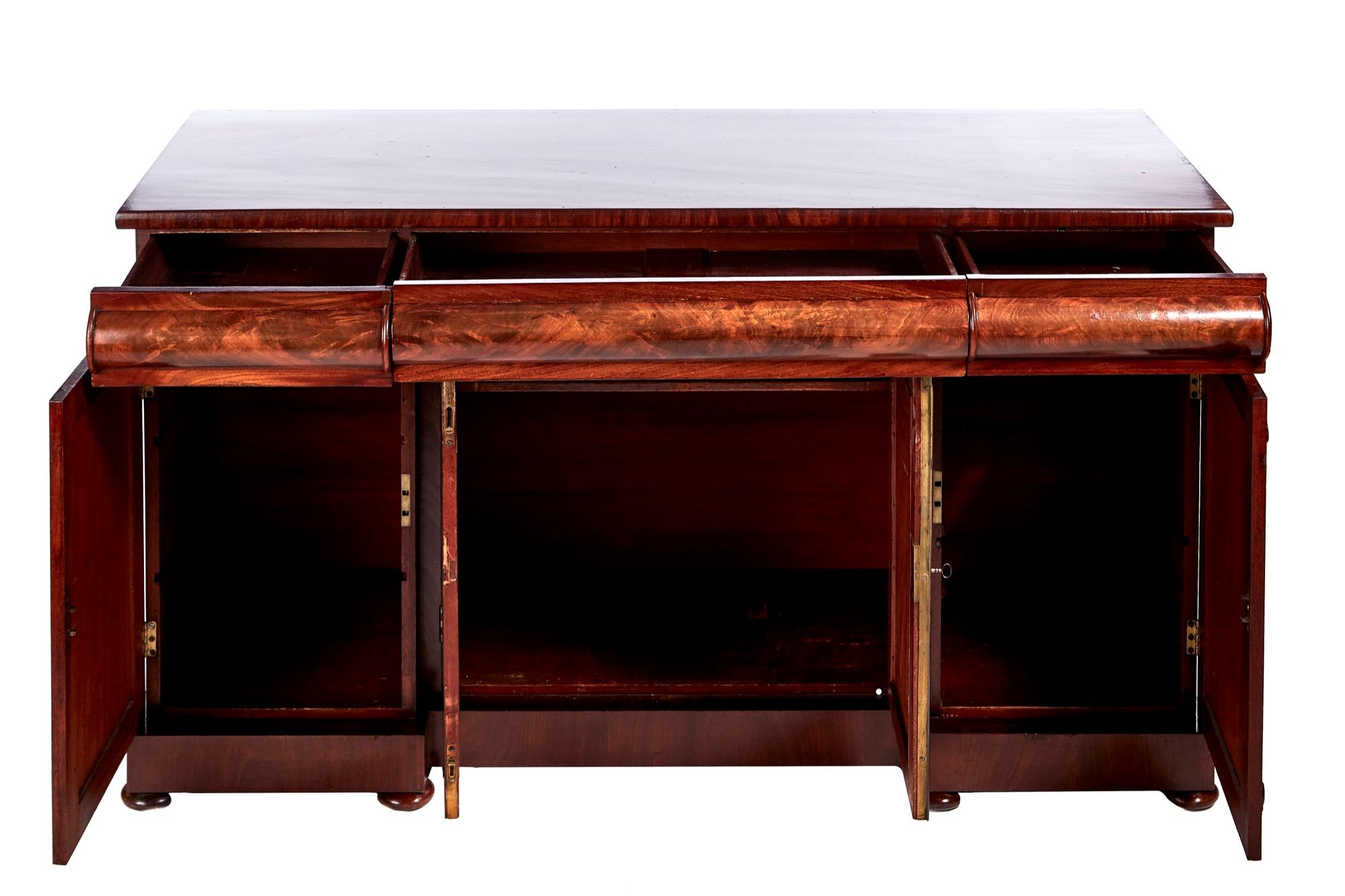 Fine quality William IV mahogany sideboard having a lovely quality mahogany top, 3 frieze drawers with shaped fronts, 4 figured mahogany panelled doors with quality carvings, standing on a plinth base with original bun feet.
Fantastic color and