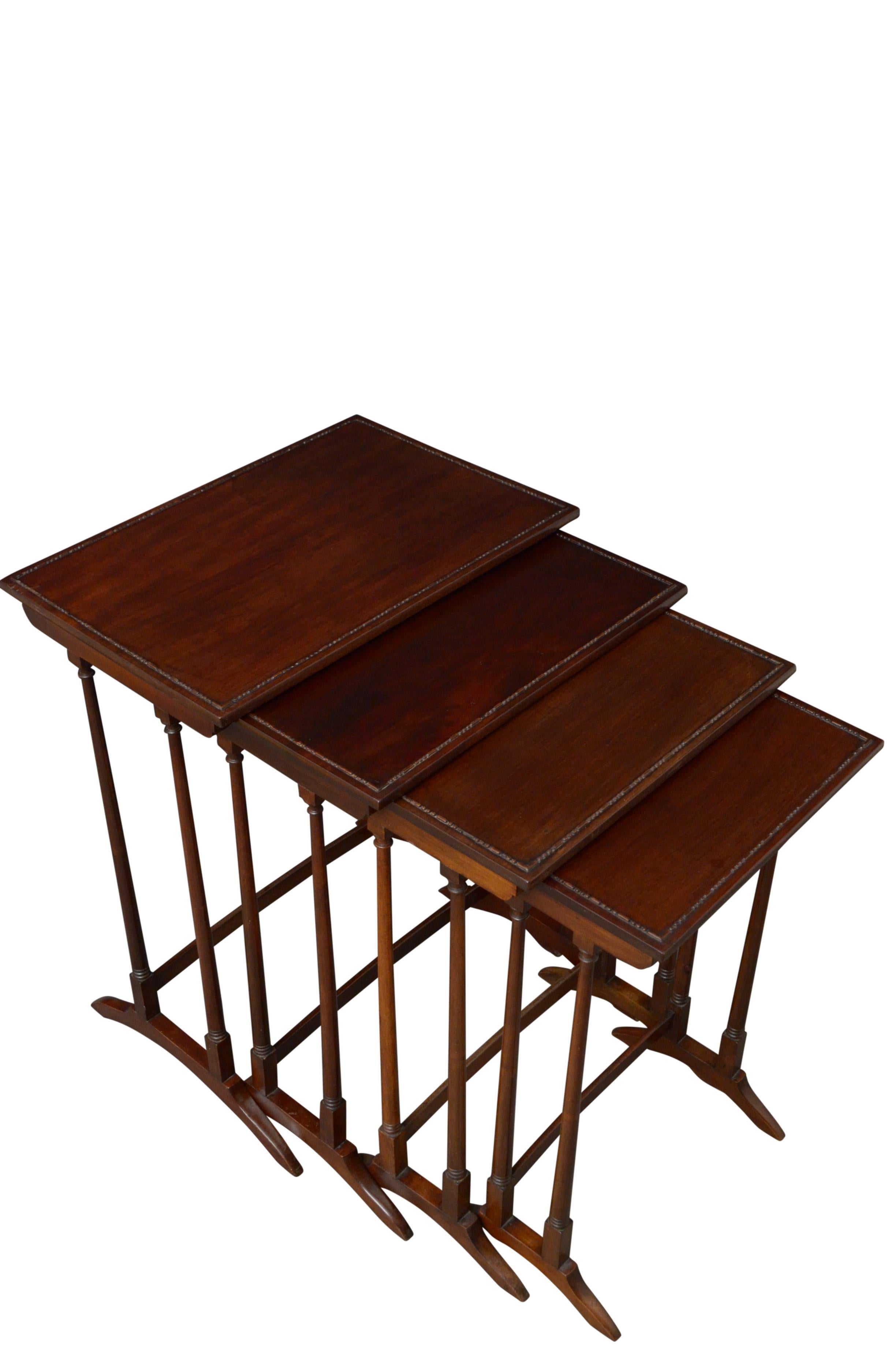 K0501 Fine quality Edwardian nest of four tables in figured mahogany, each with figured mahogany top with carved decoration, standing on slender turned legs terminating in downswept feet united by a stretcher. This antique nest of tables came from a