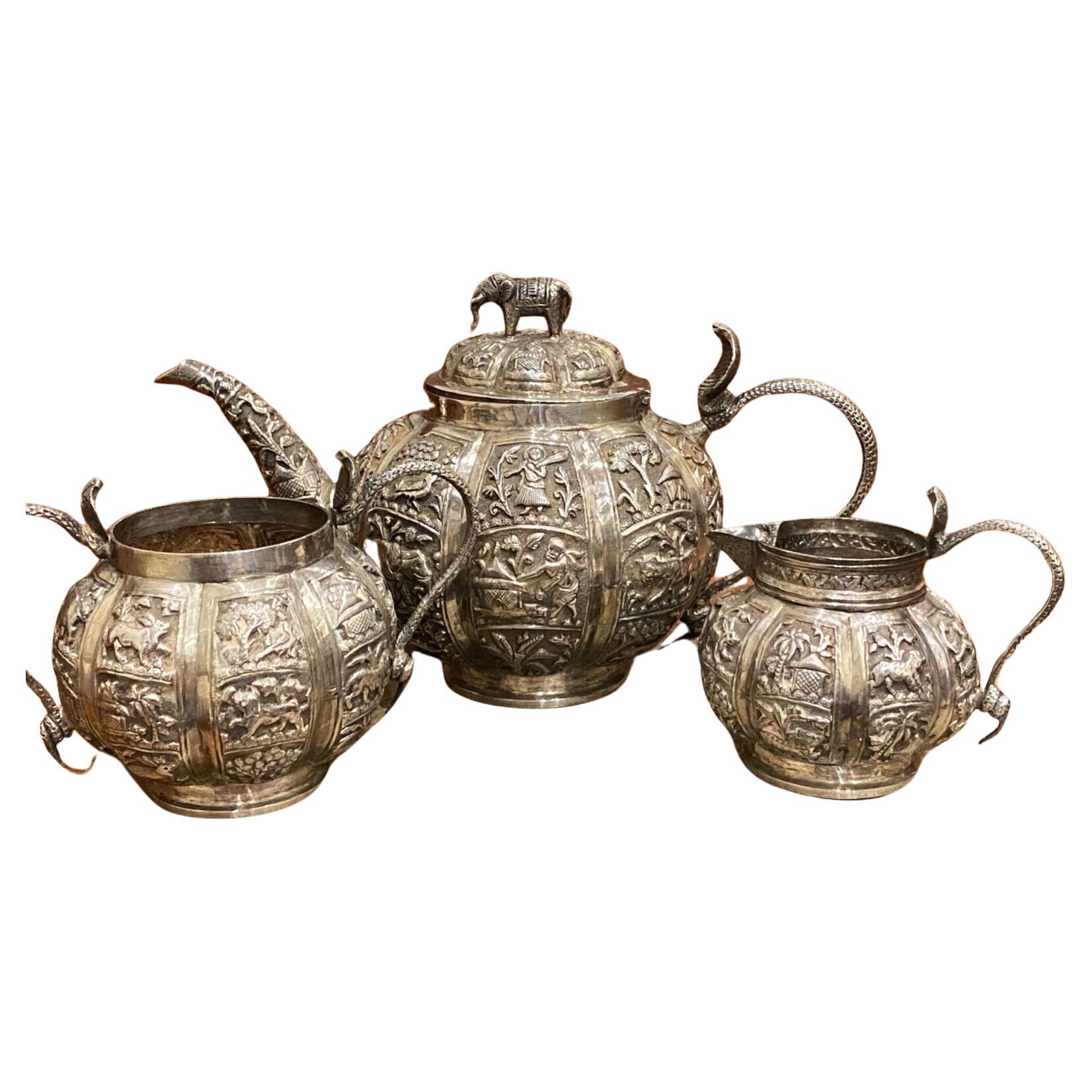 Fine & Rare Antique XIX century Indian Silver Tea Set comprising: 

- Teapot (14cm high, 25.5cm wide)
- Sugar bowl (10cm high, 15cm from one end of the handle to the other)
- Creamer (9cm high, 10.5cm wide)

all feature intricate Cobra handles, 
the