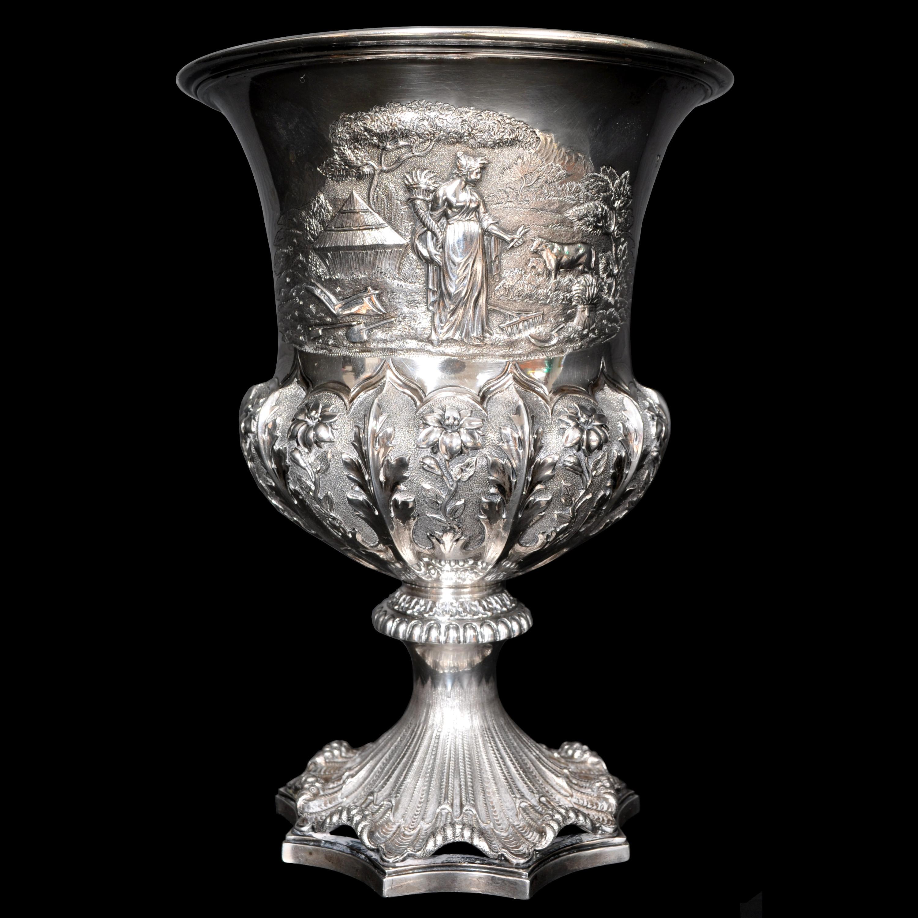 An important silver and silver gilt engraved and repousse work presentation cup, by London maker's Edward, Edward Jr, John and William Barnard, dated 1831.
An exquisite presentation cup having a flared mouth, the front of the cup decorated with a