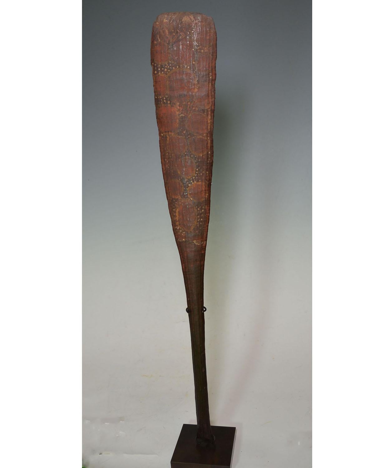 Fine rare Old Aboriginal Tiwi Islands ceremonial paddle club
The very finely carved club in hard dark wood with fluted shaft and slender elongated blade resembling a paddle,
painted on the front with circular designs and linear patterns on the