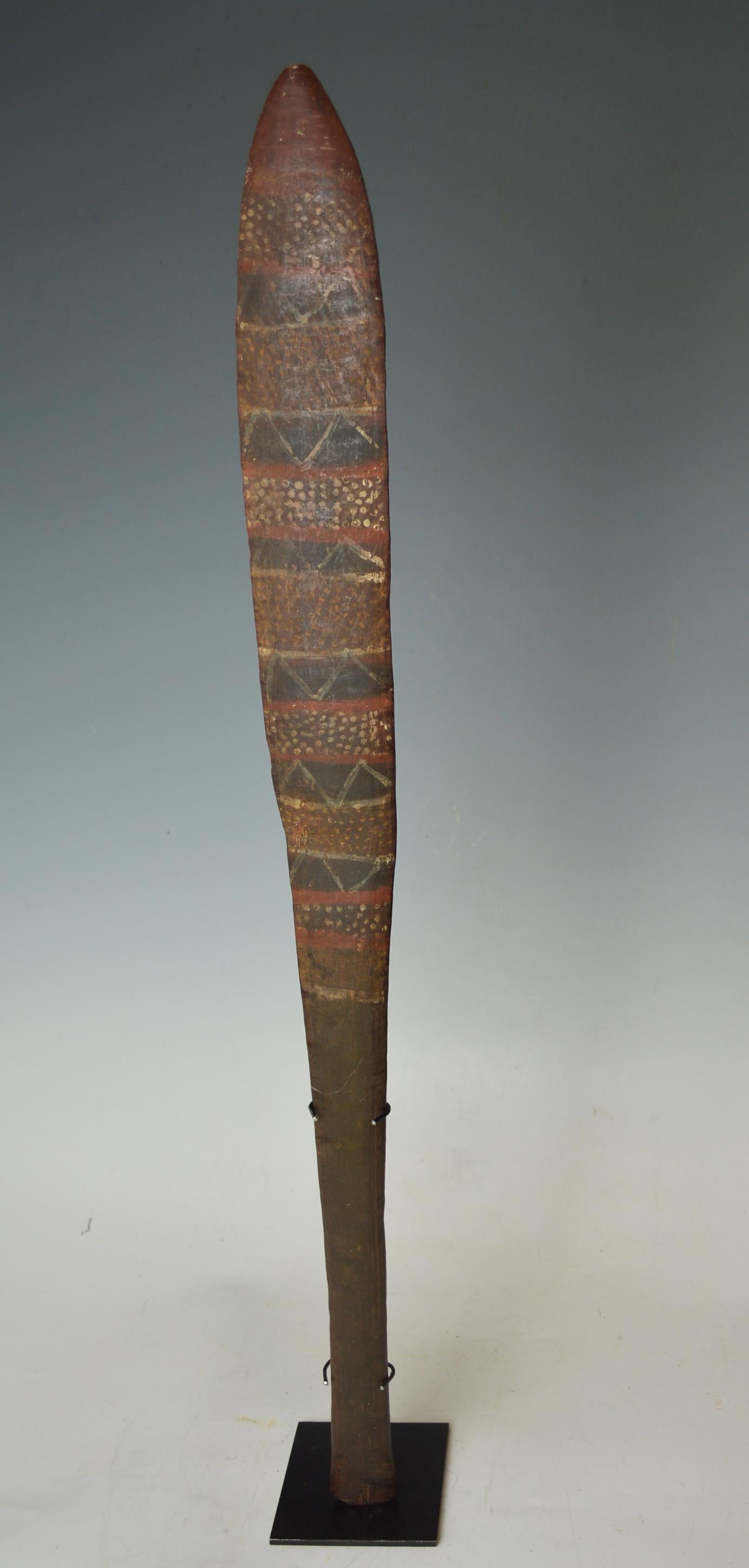 Fine rare Old Aboriginal Tiwi Islands ceremonial paddle club
The very finely carved club in hard dark wood with fluted shaft and slender elongated blade resembling a paddle,
painted with circular designs and linear patterns on the front and back,